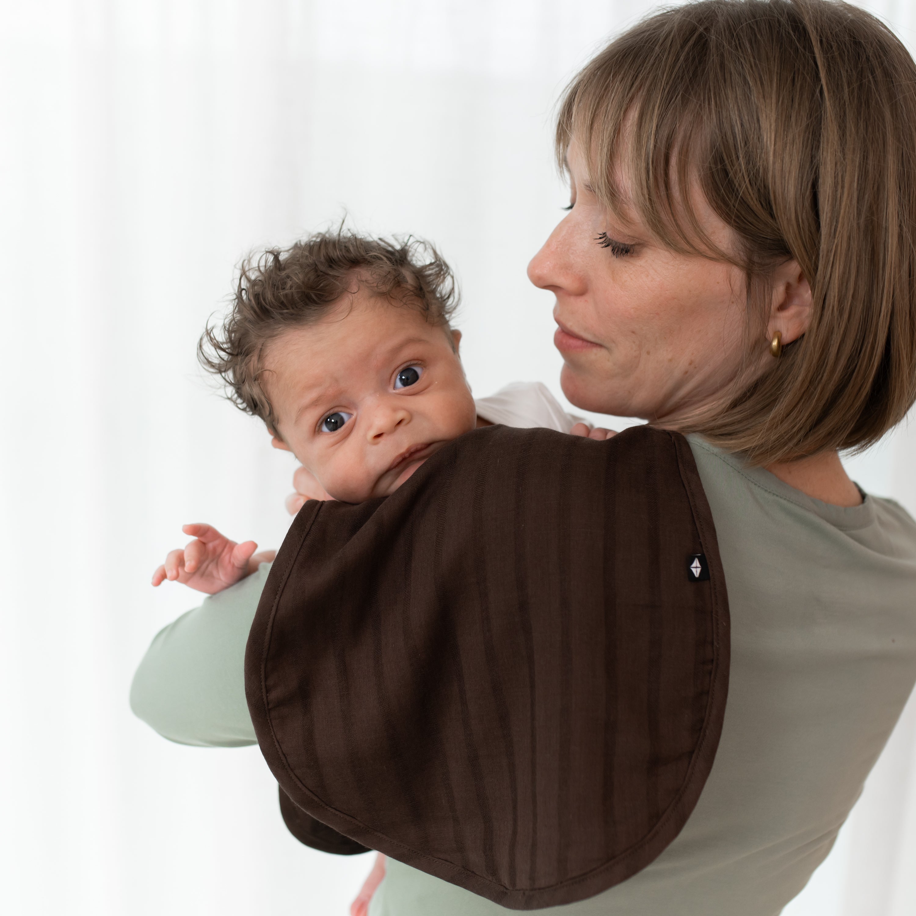 Mom Holding Baby While Using Brown Bamboo Muslin Burp Cloth