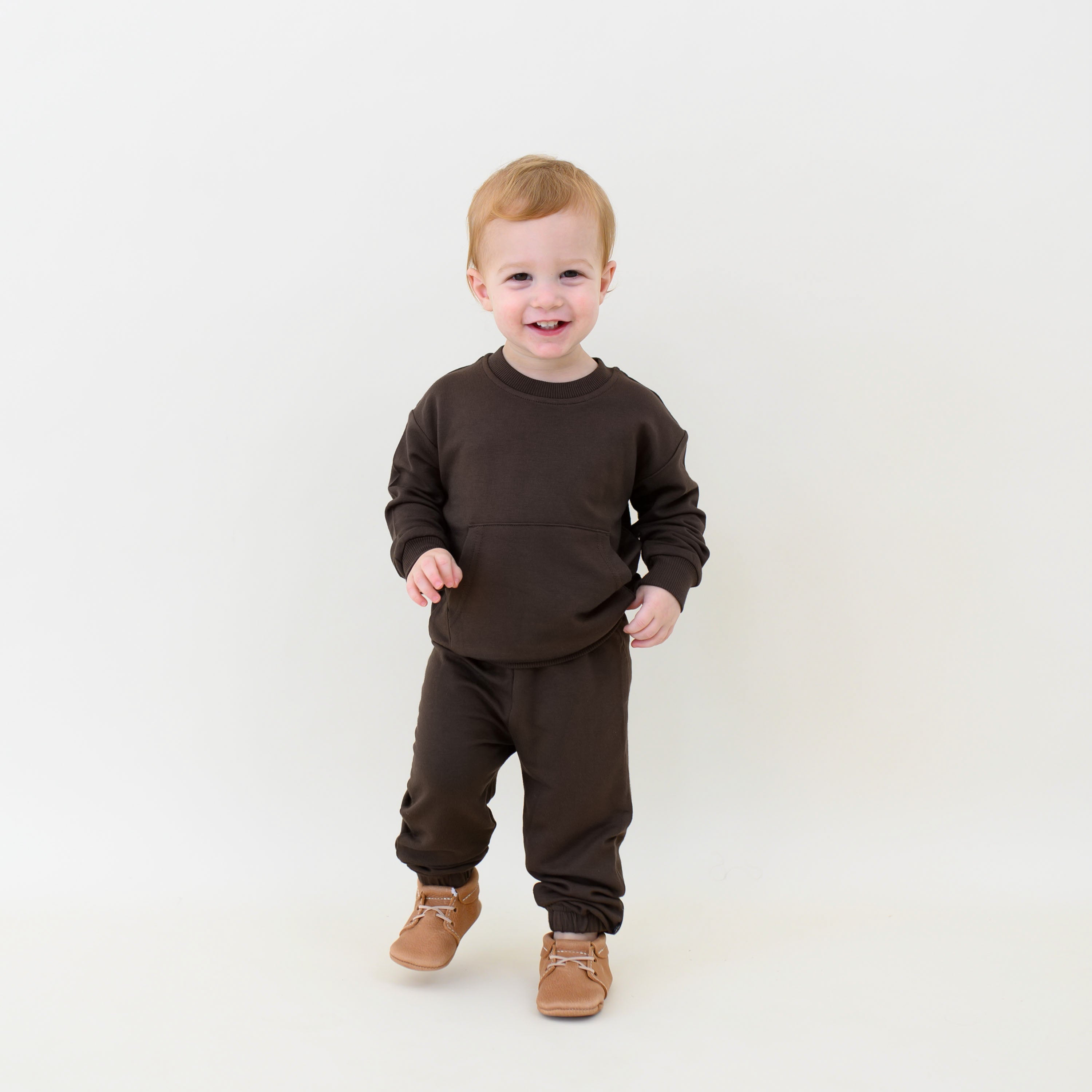 Young smiling boy walking wearing the French Terry Jogger Set in Espresso