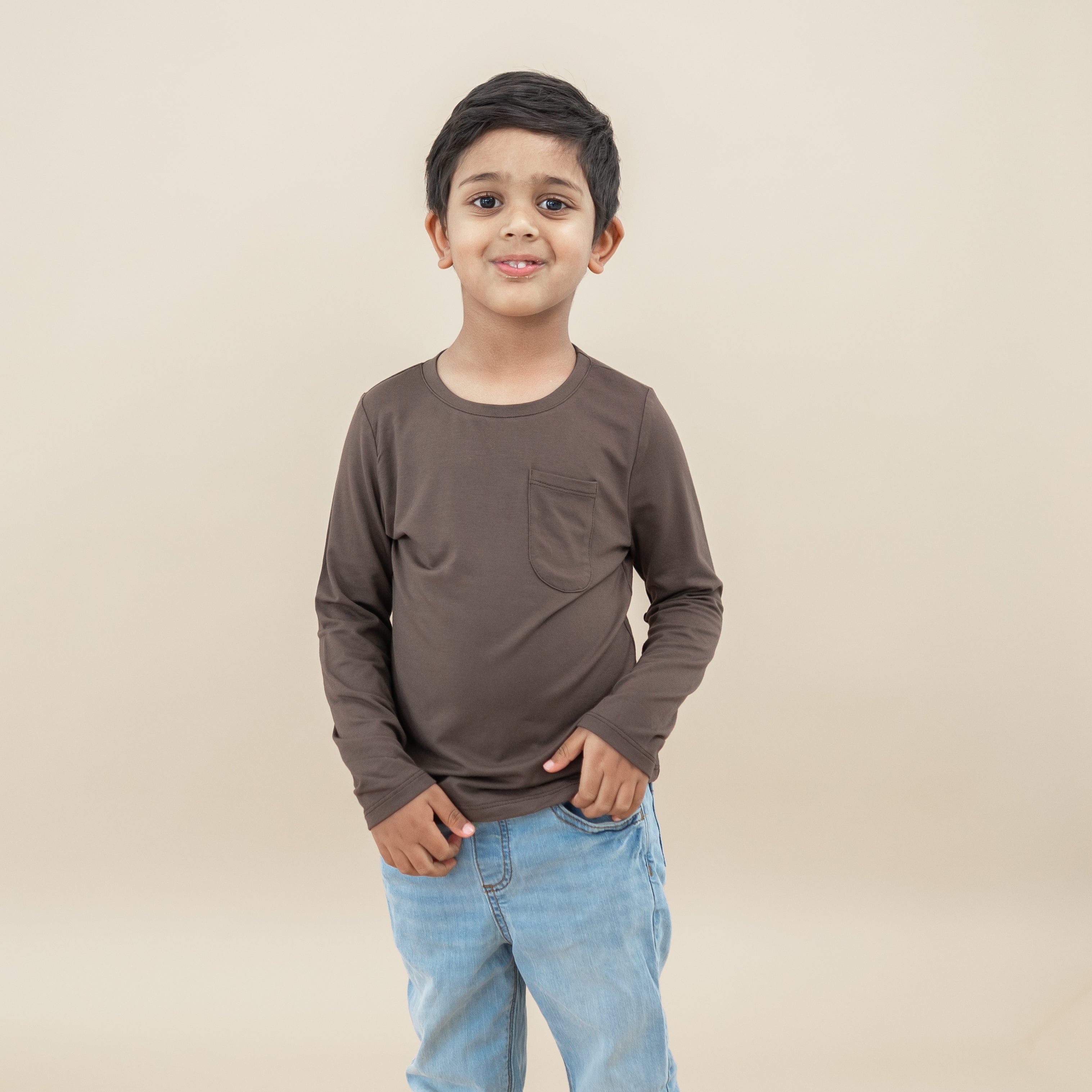 Boy model standing wearing the Long Sleeve Toddler Crew Neck Tee in Espresso paired with jeans