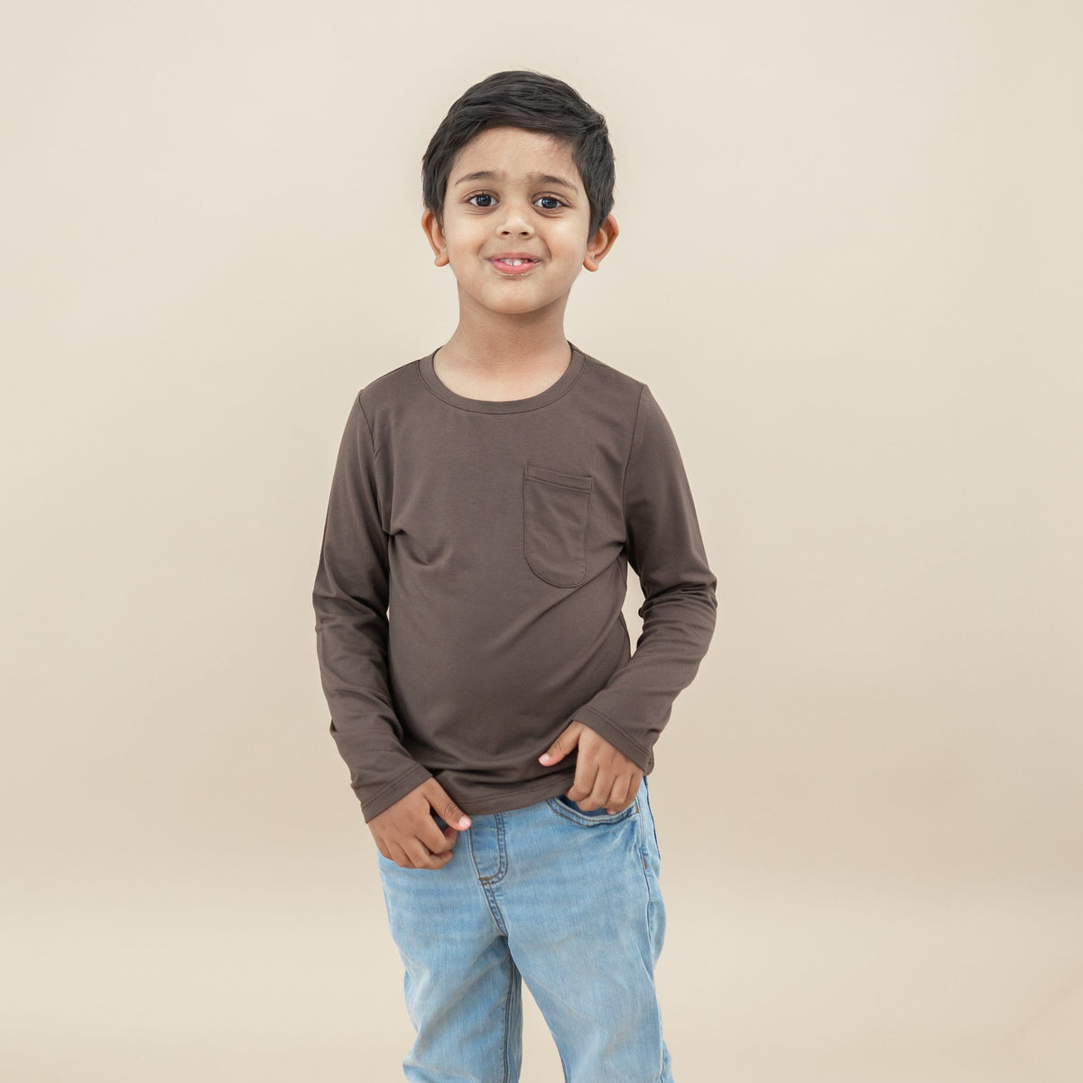 Boy model standing wearing the Long Sleeve Toddler Crew Neck Tee in Espresso paired with jeans