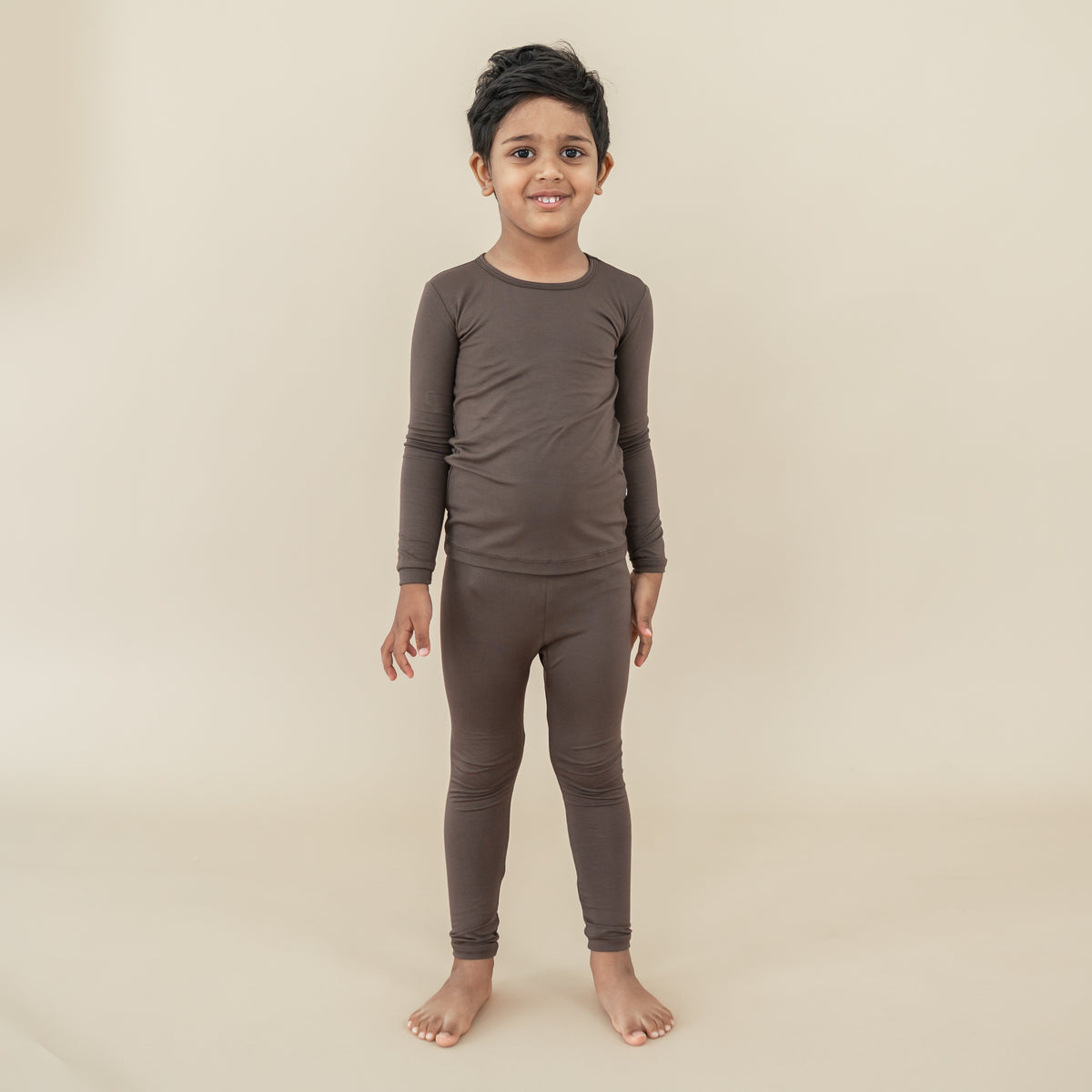 Boy model standing wearing the Long Sleeve Pajamas in Espresso