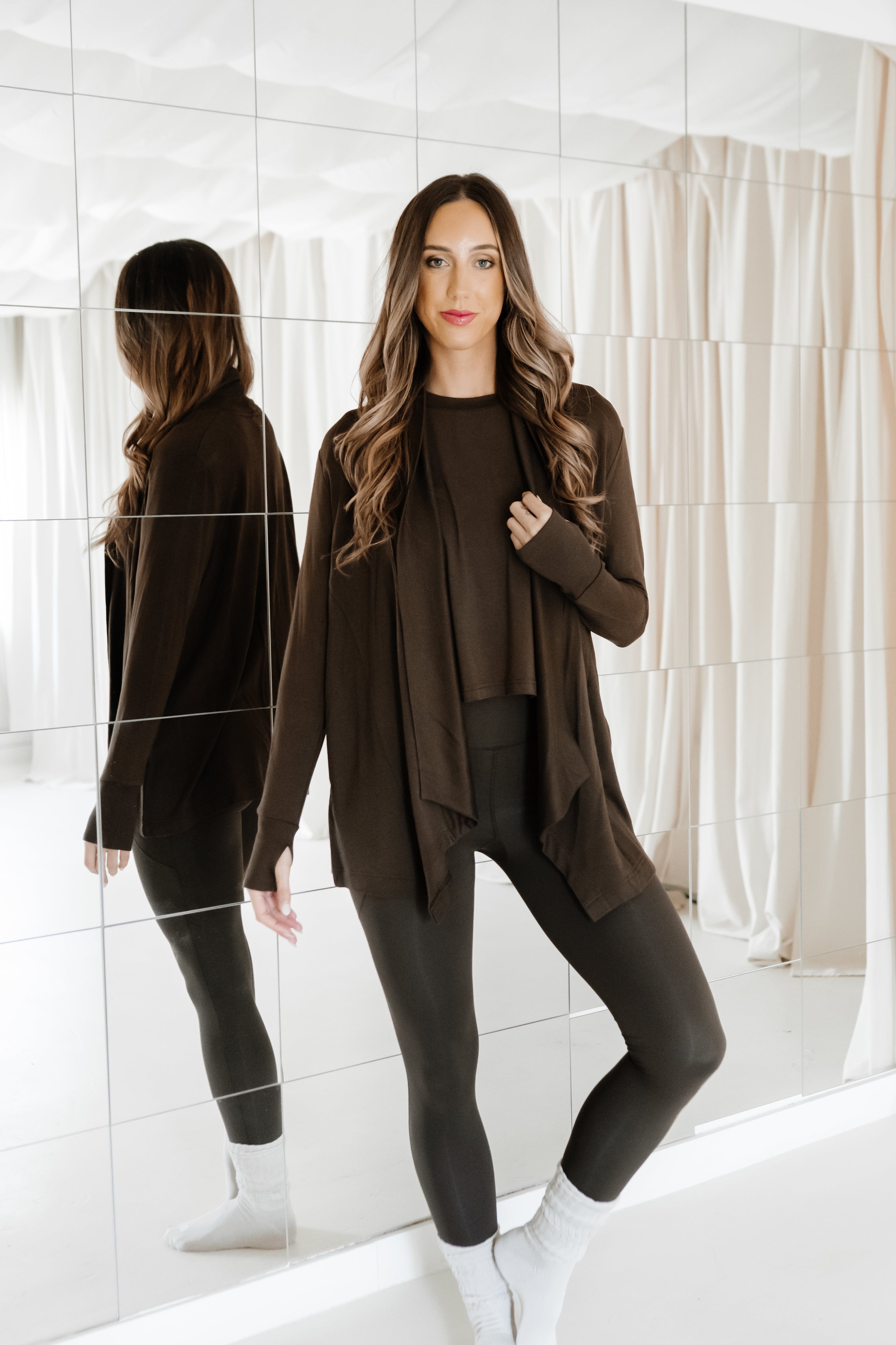 Model standing in front of a mirror wearing the Bamboo Flex Women’s Leggings in Espresso with matching short sleeve tee and matching french terry wrap