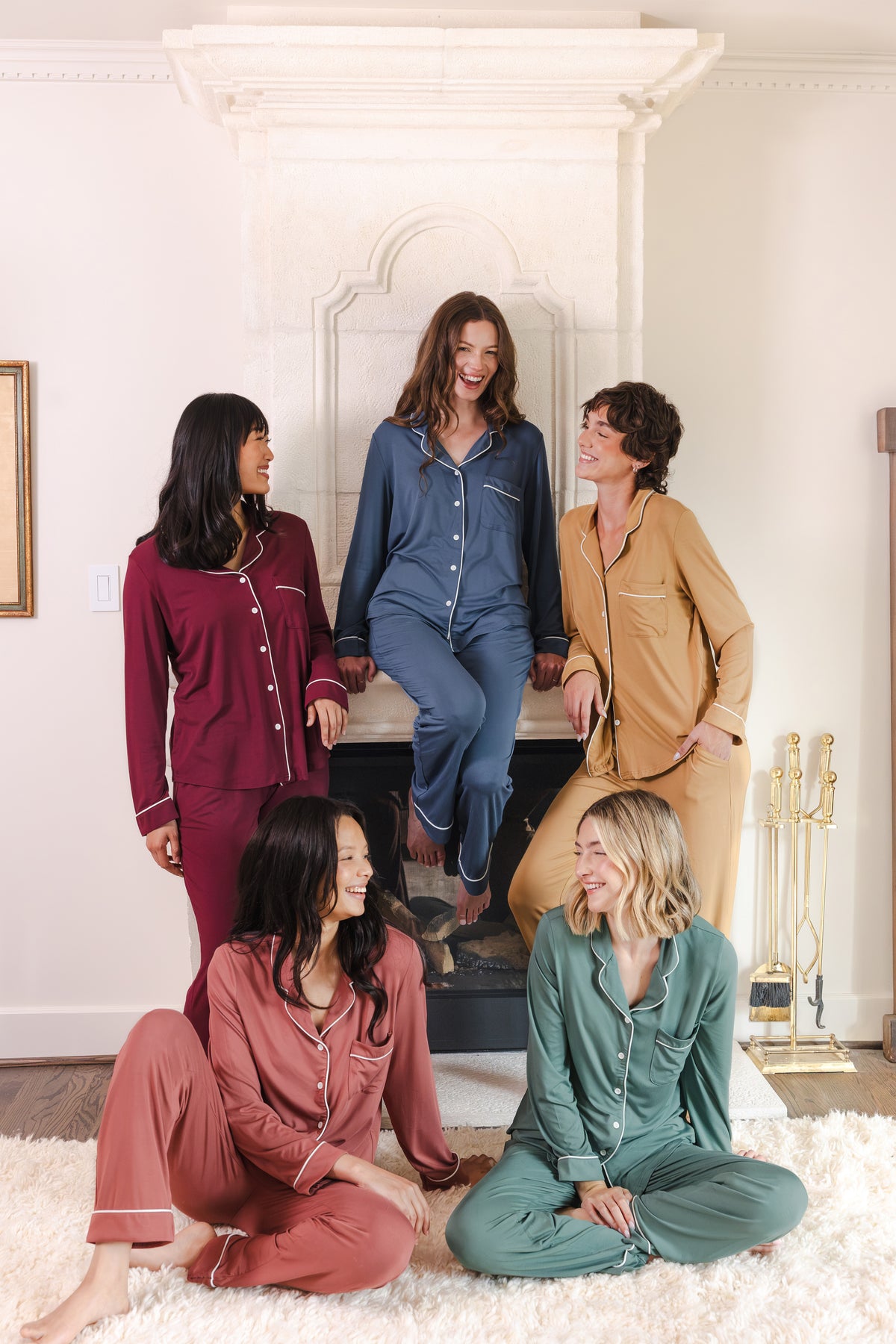 5 modals wearing Long-Sleeved Women's Pajama Set in Burgundy, pine, oxford, ochre and ember sitting in a living room