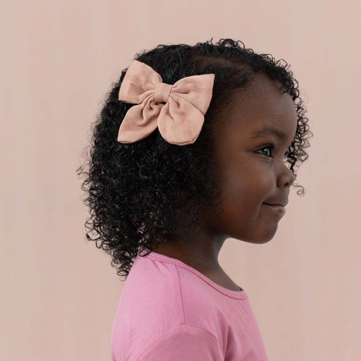 Toddler wearing Bamboo Muslin Alligator Clip Bow in Fawn