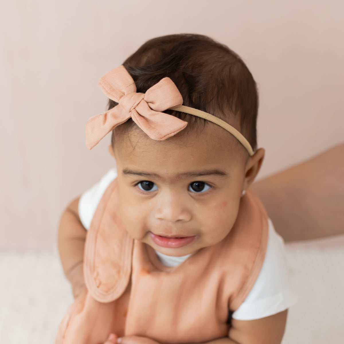 Baby wearing Medium Bamboo Muslin Bow in Fawn