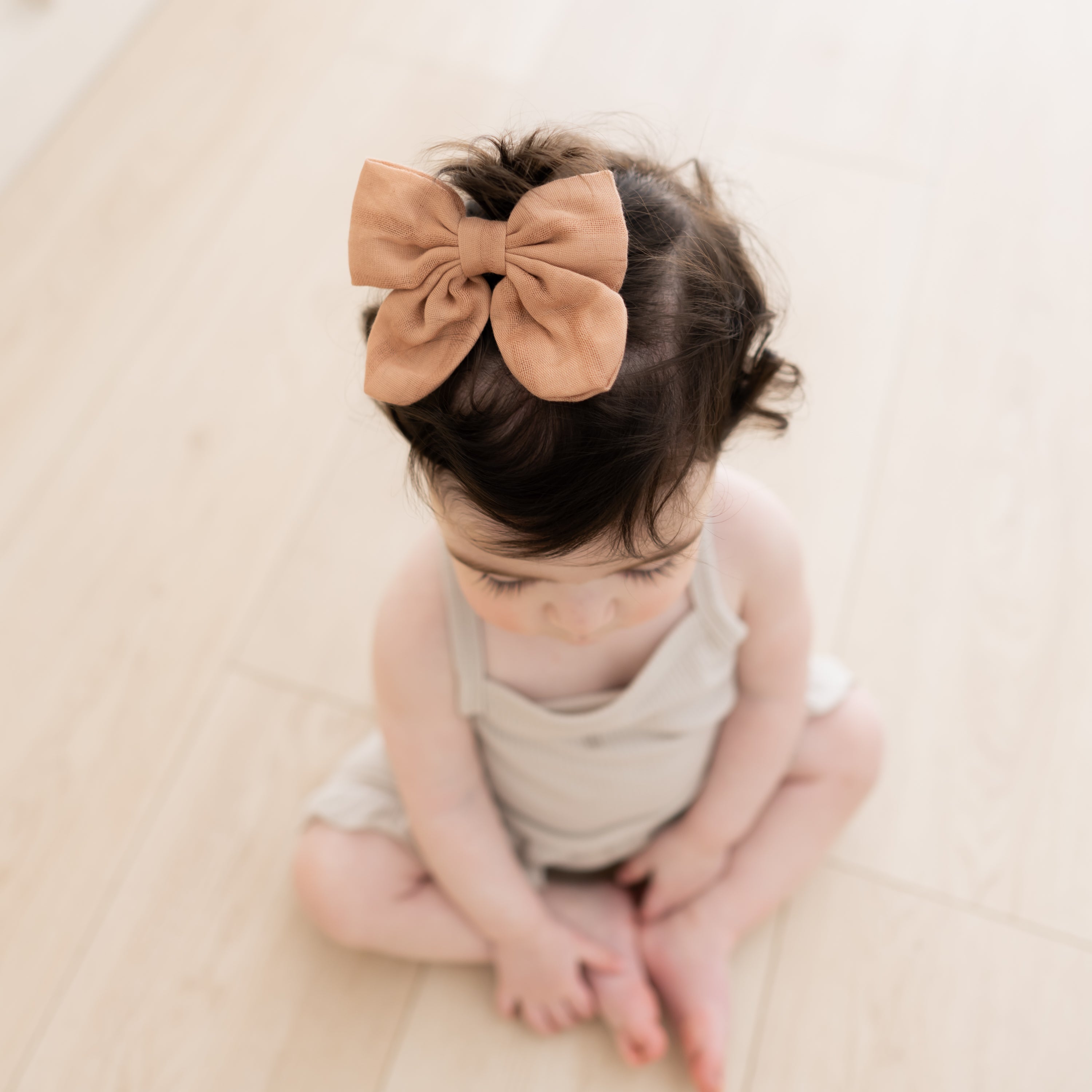 Baby wearing Bamboo Muslin Bow with Alligator Clip in Fawn
