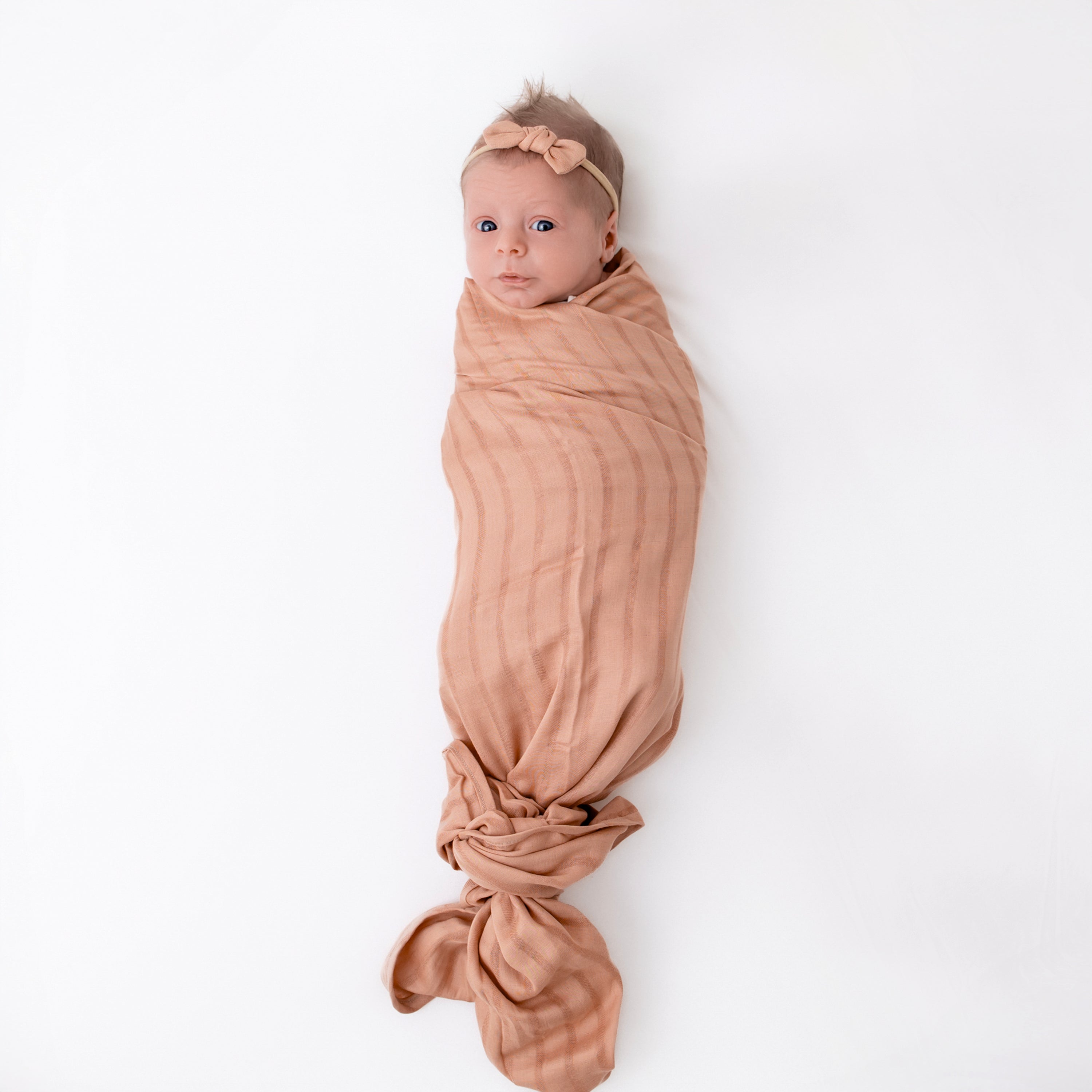 Baby swaddled in Bamboo Muslin Swaddle Blanket in Fawn