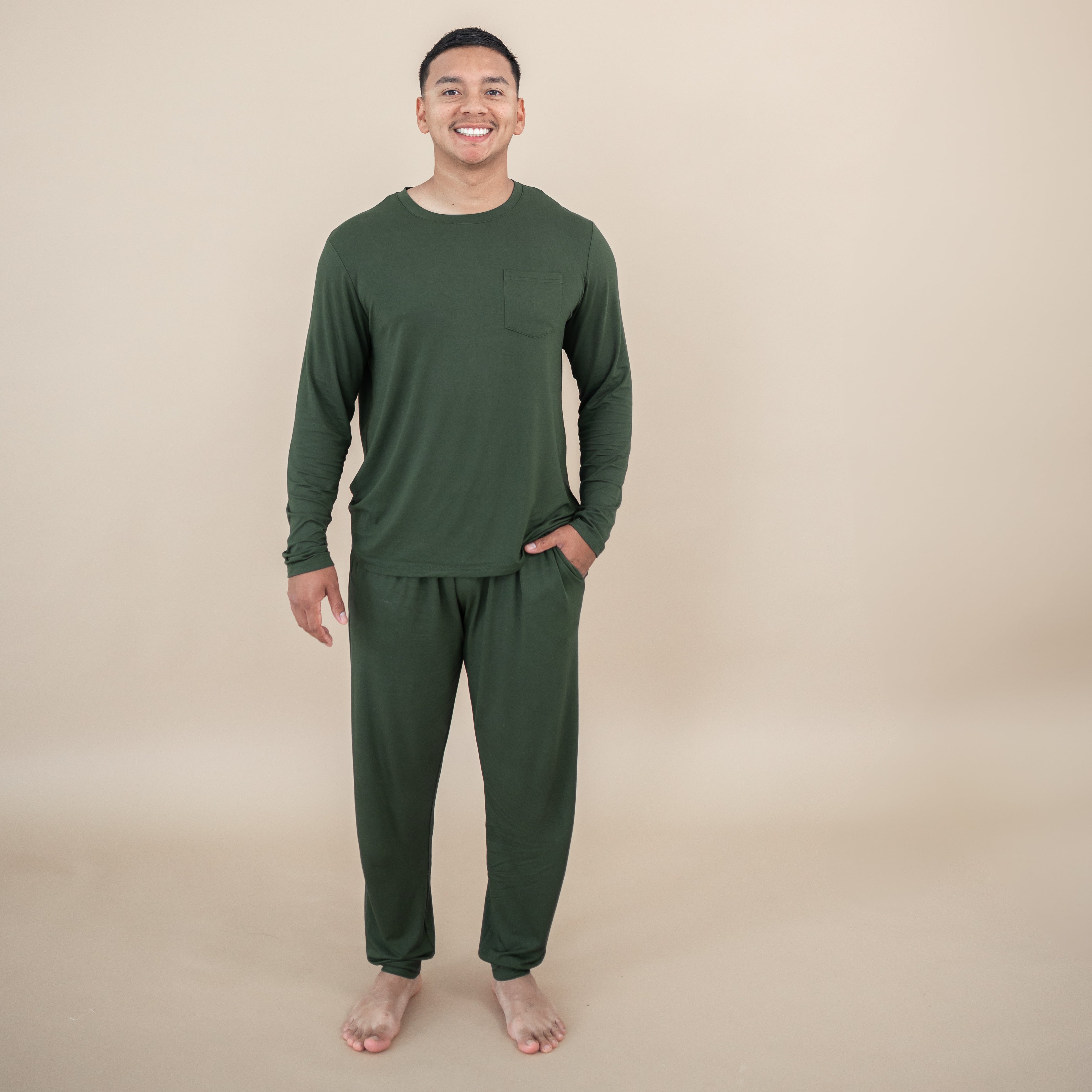 Man wearing a Men's Jogger Set in Fir against a beige background