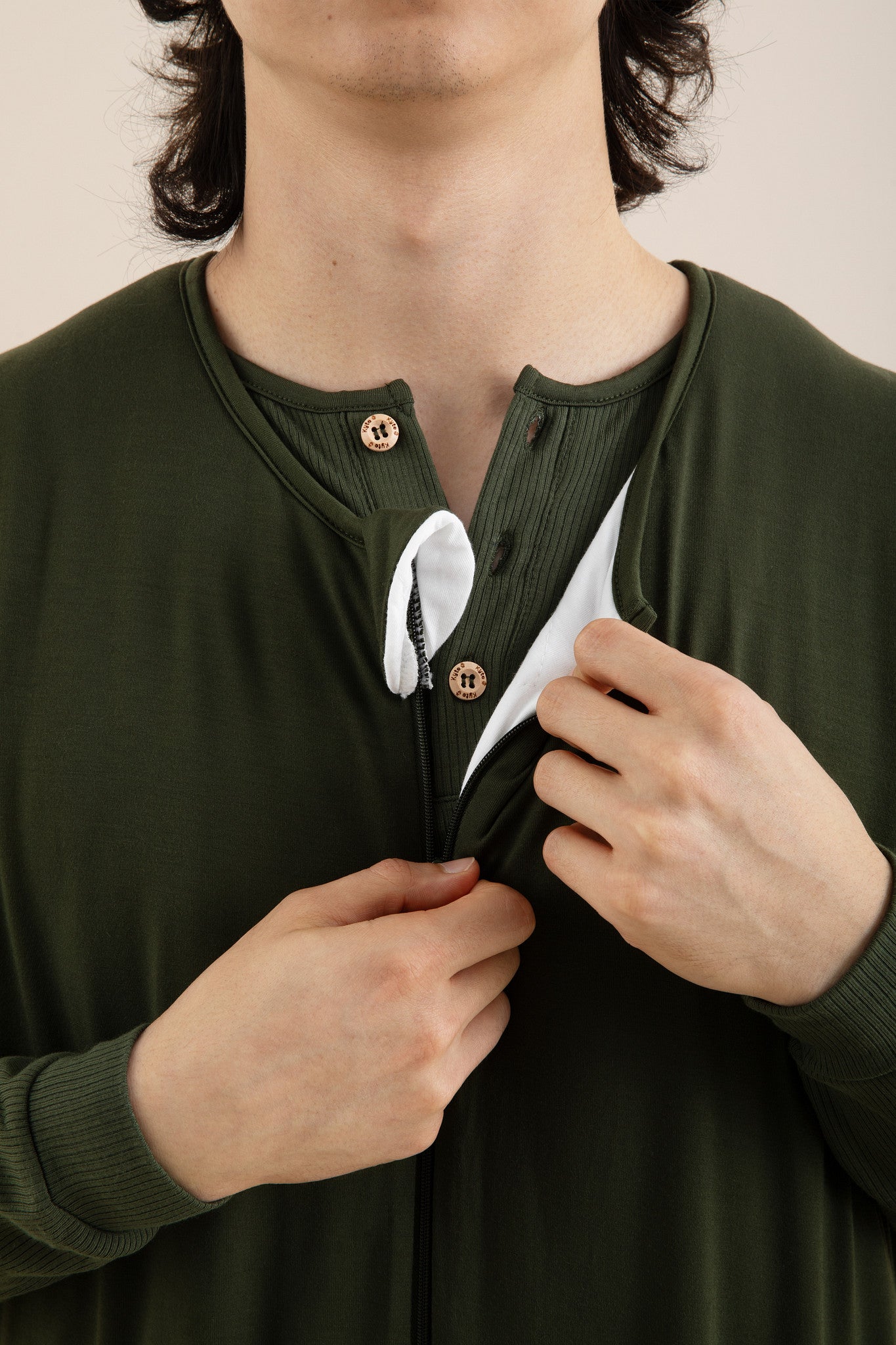 Male undoing the zipper on the Adult Sleep Bag Walker in Fir