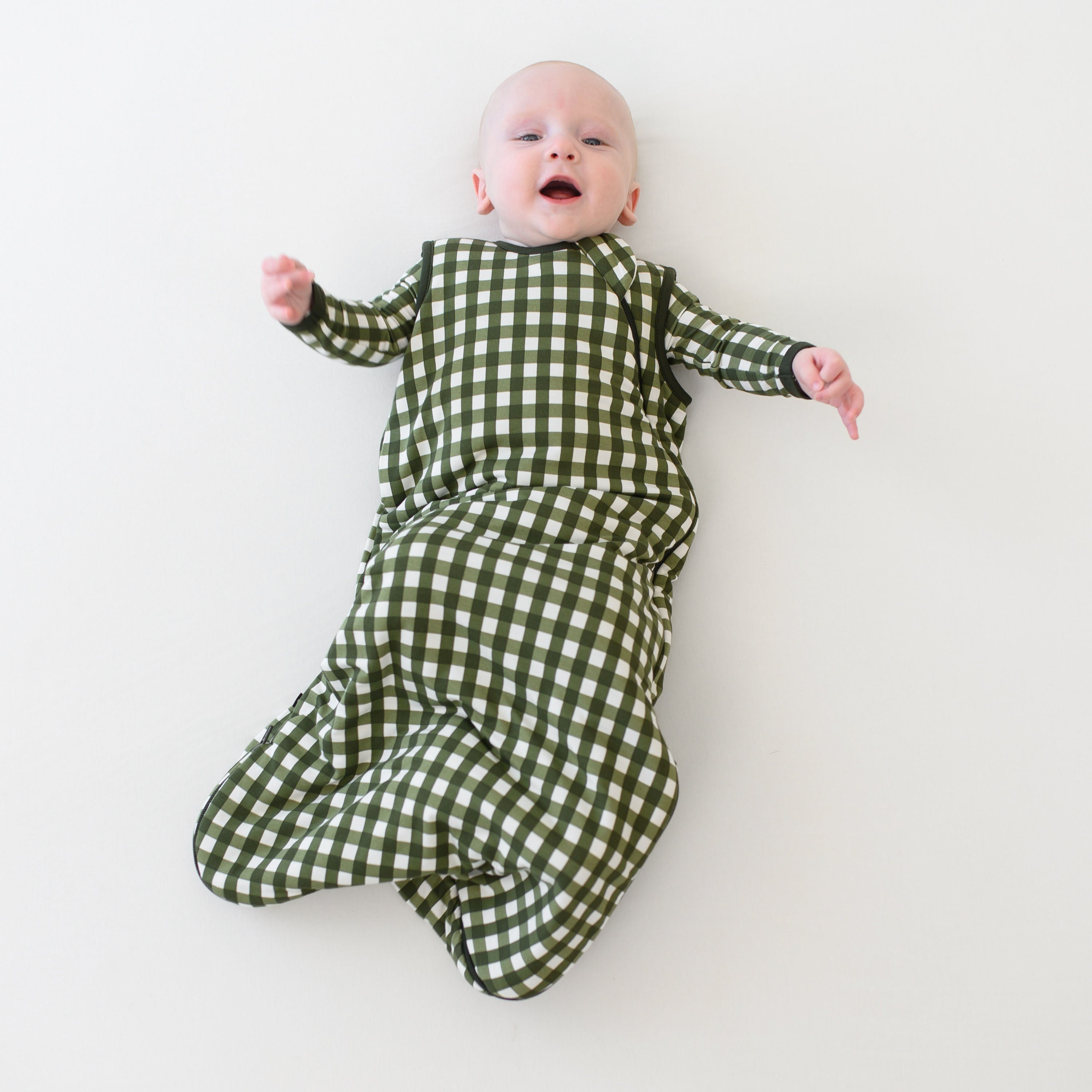 Infant wearing Sleep Bag in green Gingham Fir 1.0 TOG with long sleeve pajamas