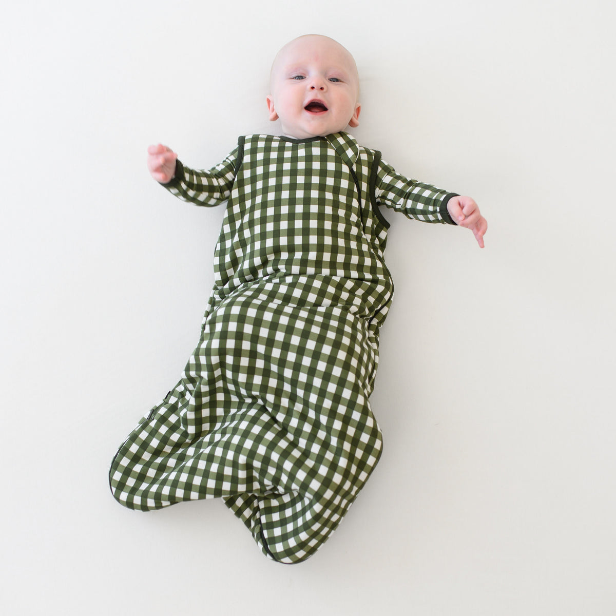 Infant wearing Sleep Bag in green Gingham Fir 1.0 TOG with long sleeve pajamas