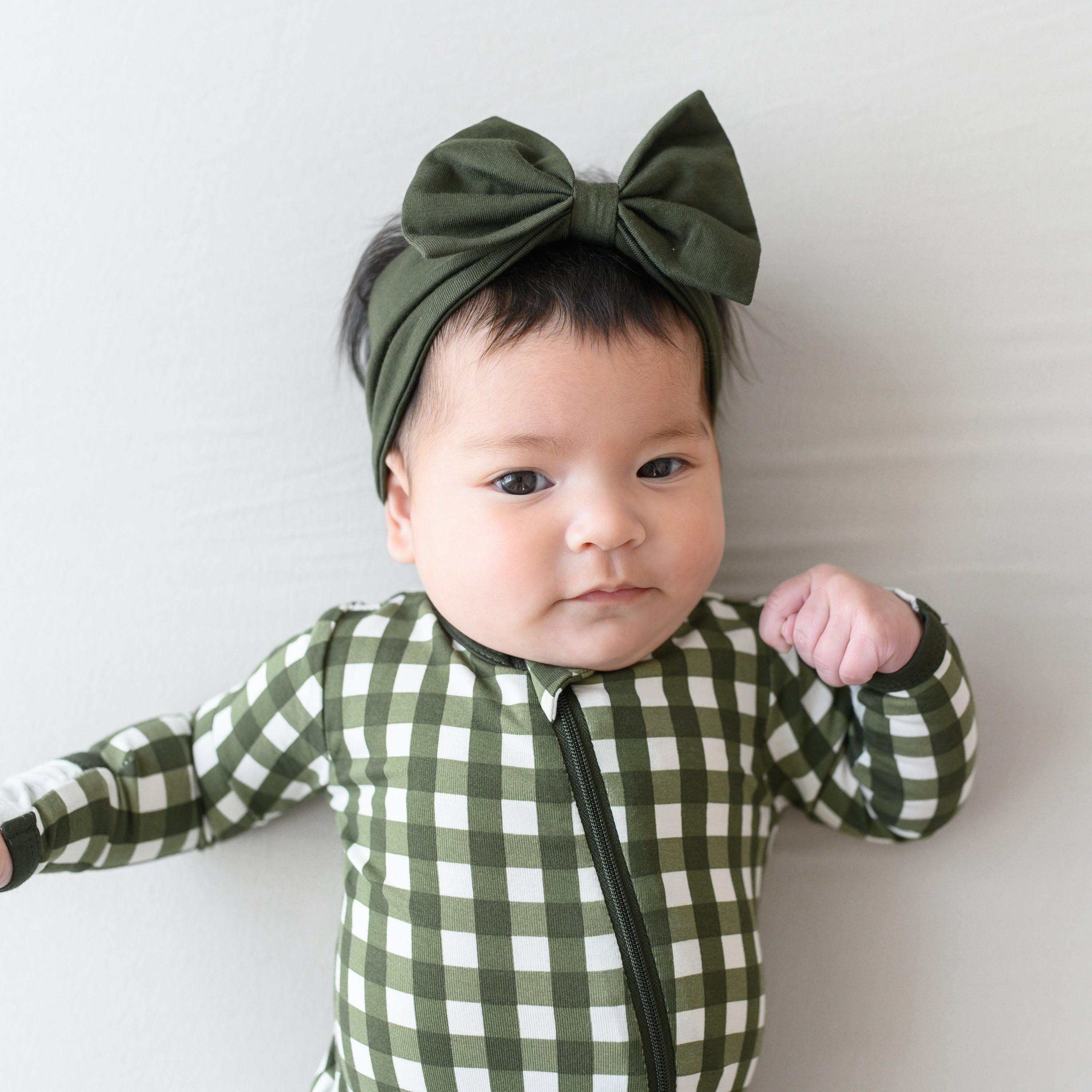 Close up of the Zipper and zipper garage on the Zippered Romper in Gingham Fir shown on an infant model