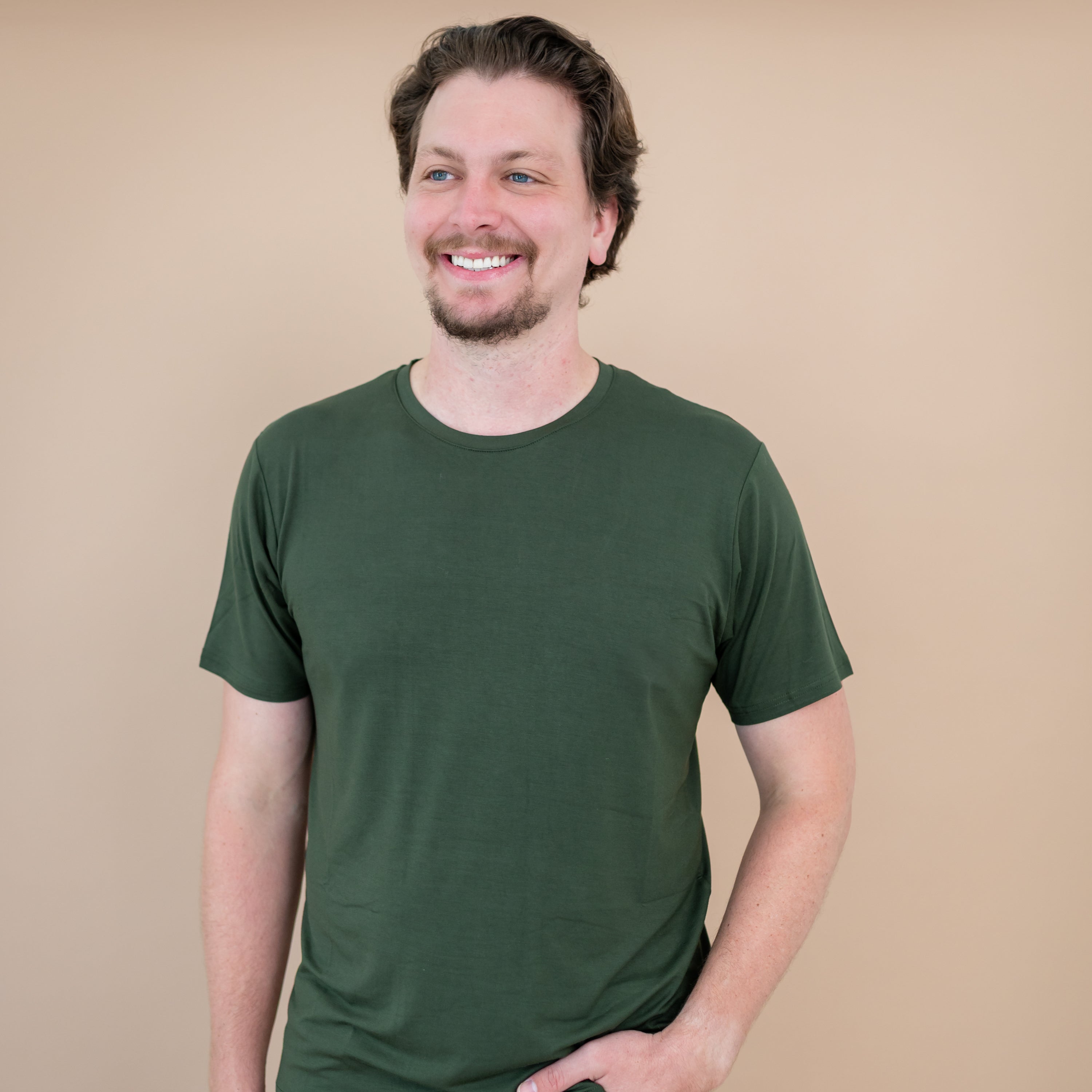 Man wearing a green t-shirt against a beige background