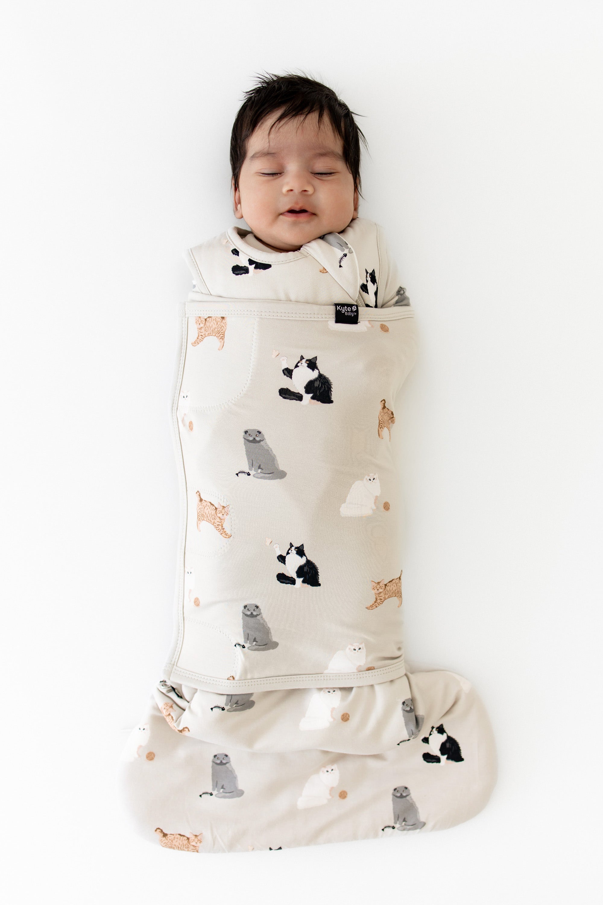 Sleeping newborn wearing the Sleep Bag Swaddler in Fluffy Cat 1.0