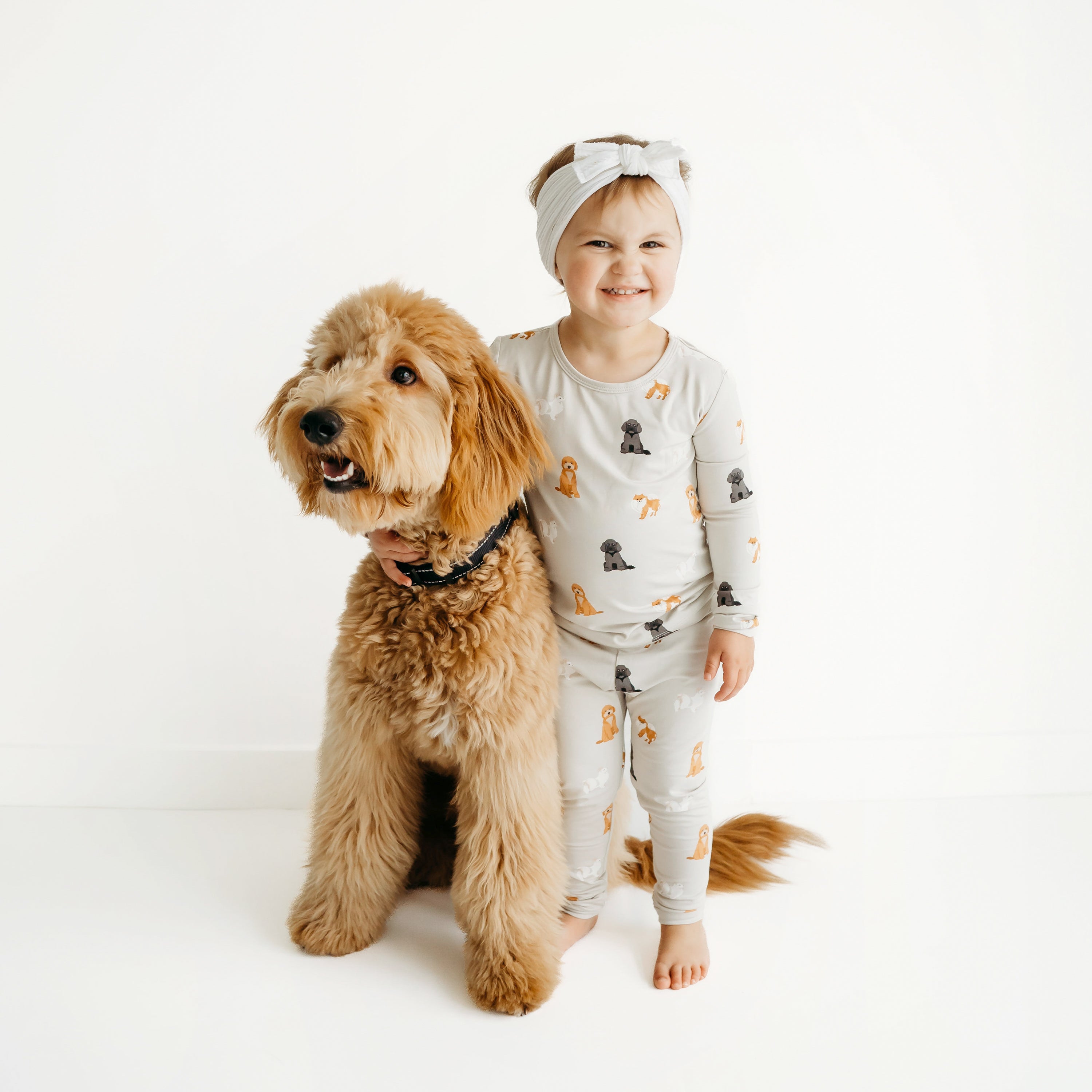 Toddler wearing Long Sleeve Pajamas in Fluffy Dog next to a real dog