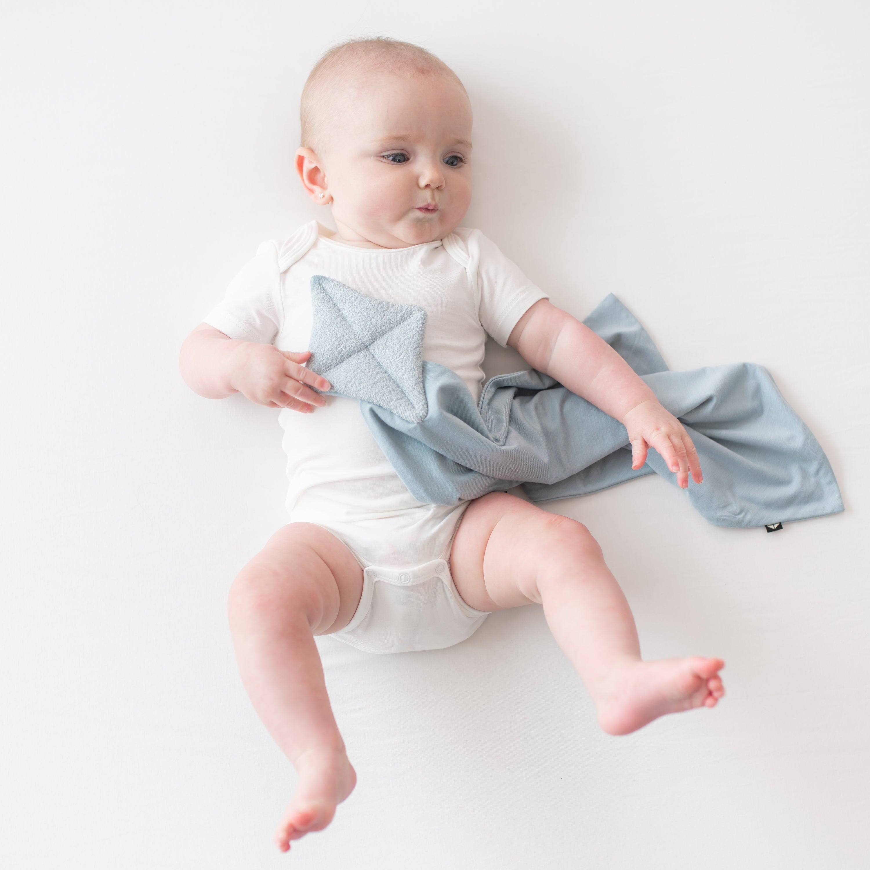 Baby in cloud bodysuit holding Kite Lovey in Fog
