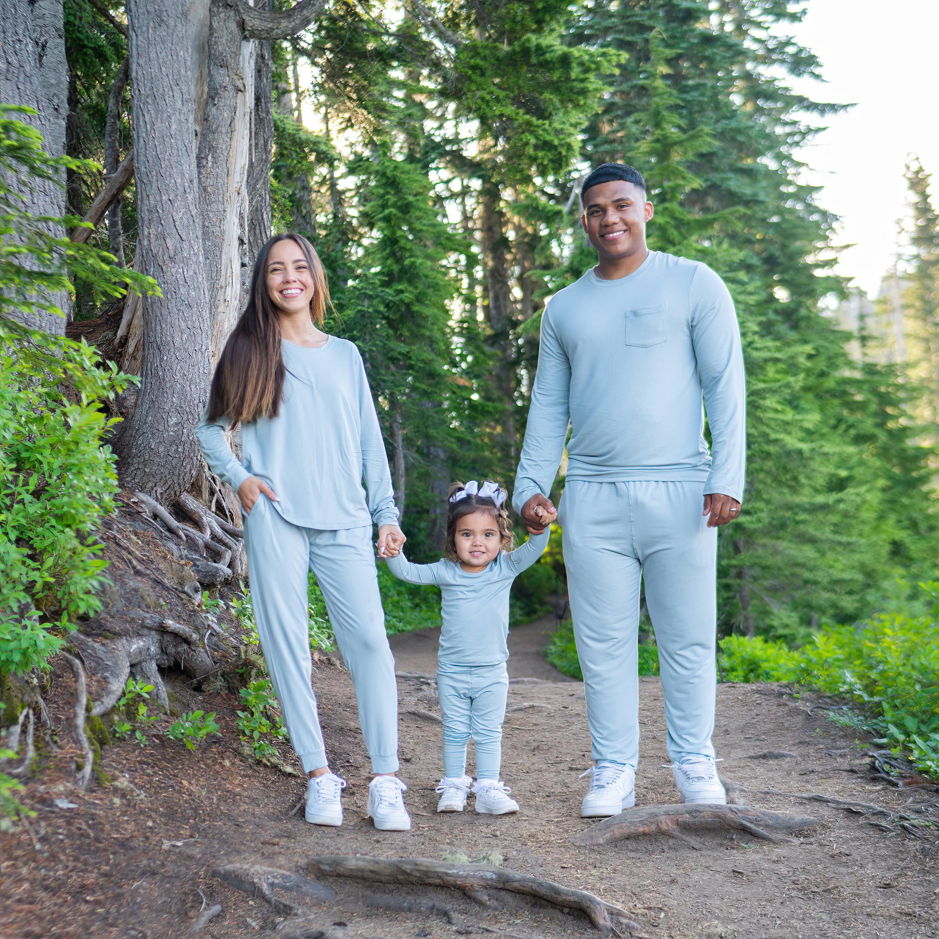photo of mom, dad and toddler wearing matching fog pajamas in a forest