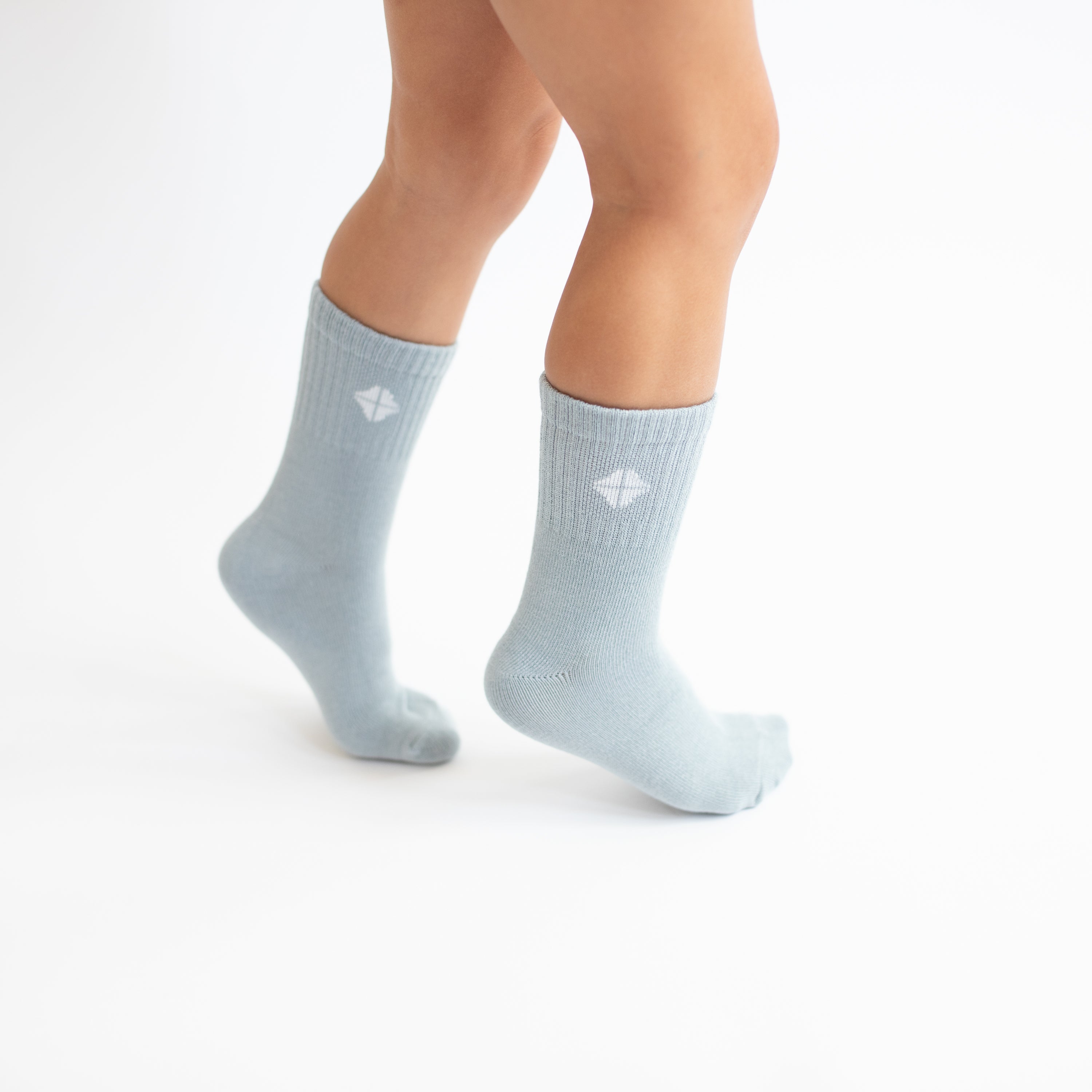 Crew Socks in Fog shown on a toddler model with the Kyte Baby logo visible