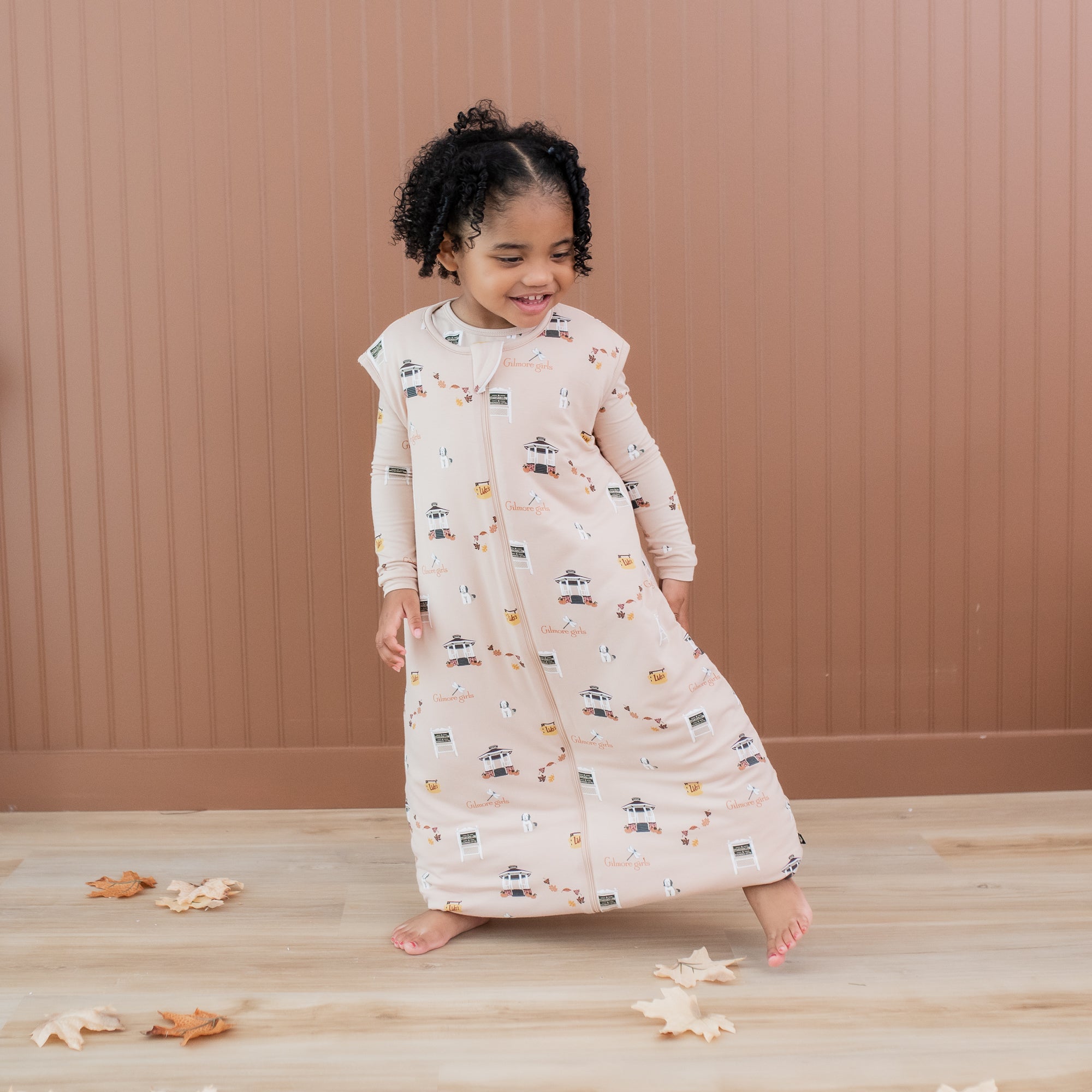 Young girl walking in front of a brown paneled wall wearing the Sleep Bag Walker in Gilmore Girls 1.0