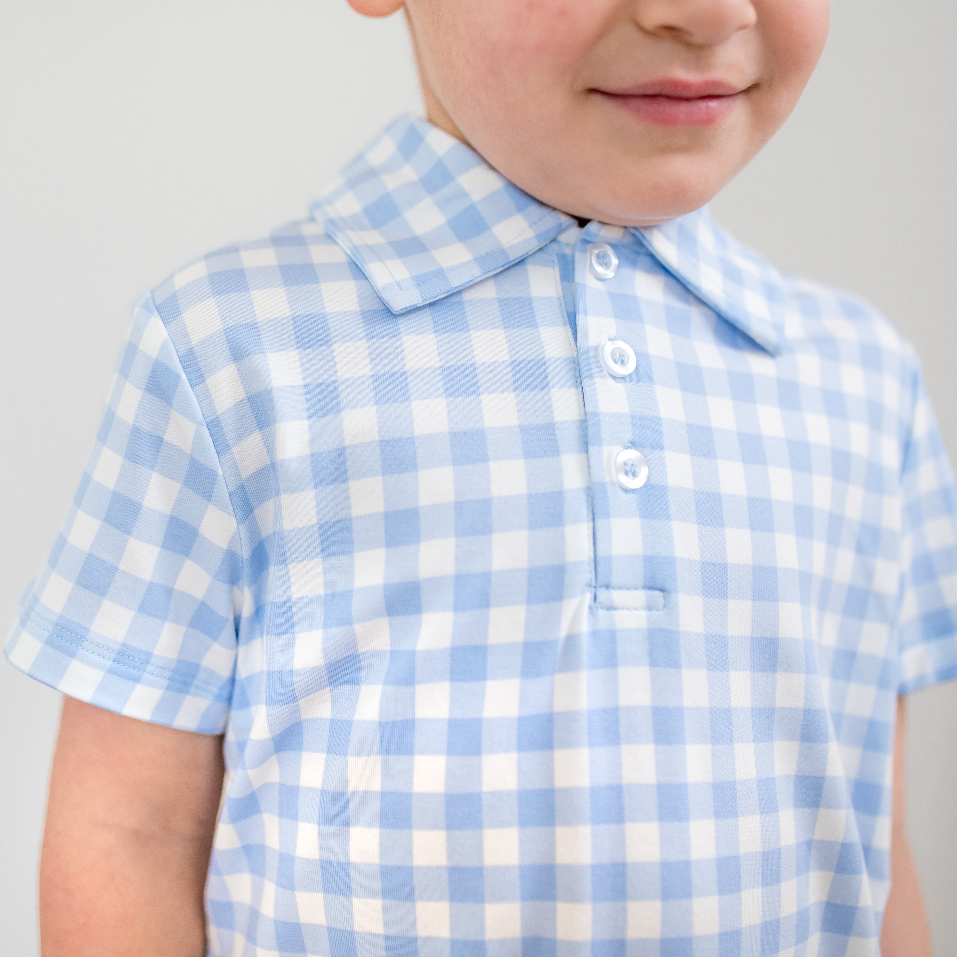 Close up of the blue and white checks on the Toddler Short Sleeve Polo in Gingham Breeze with the showing the button placket and collared neck
