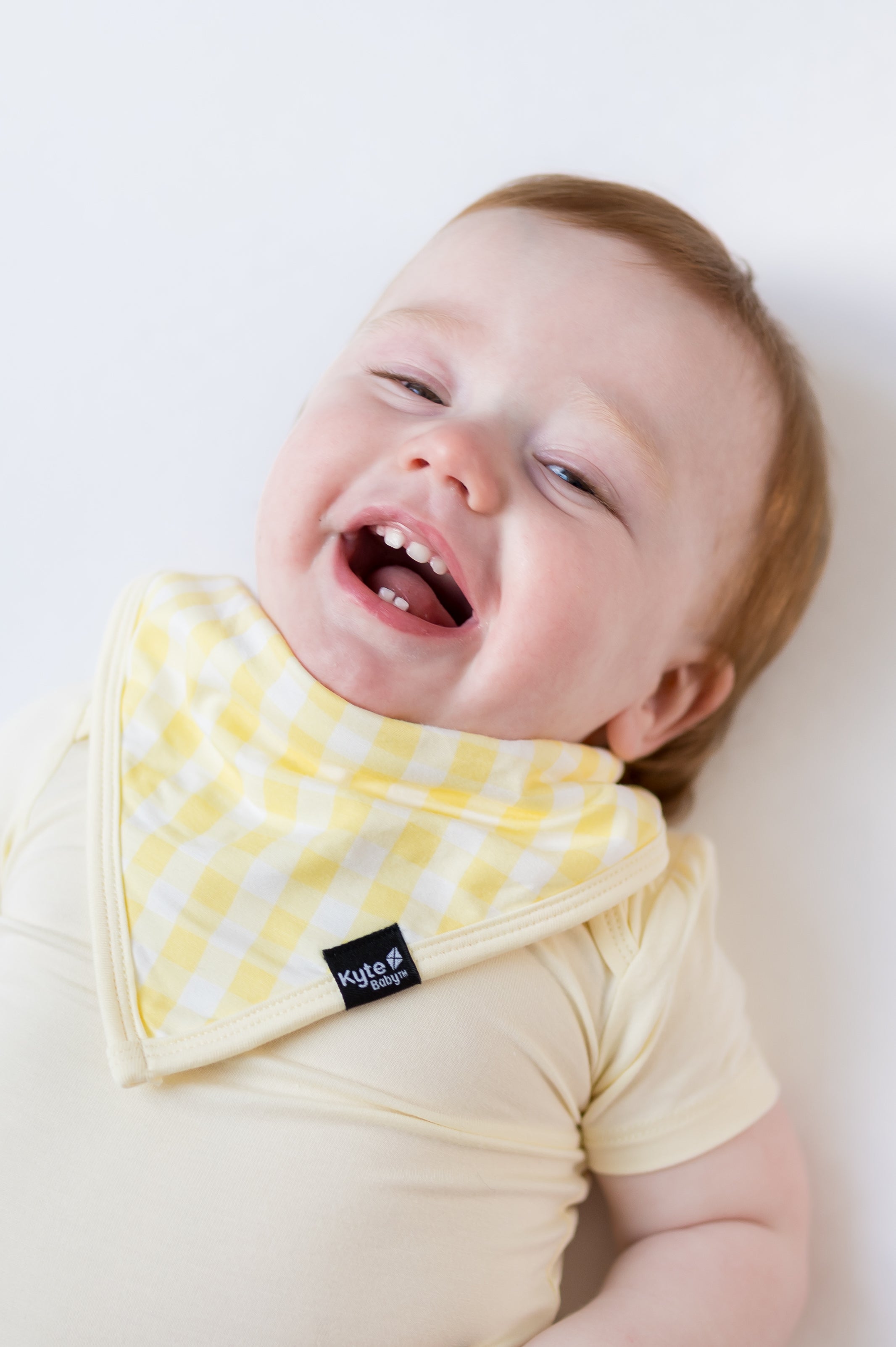 Smiling boy wearing the Bib in Gingham Chamomile