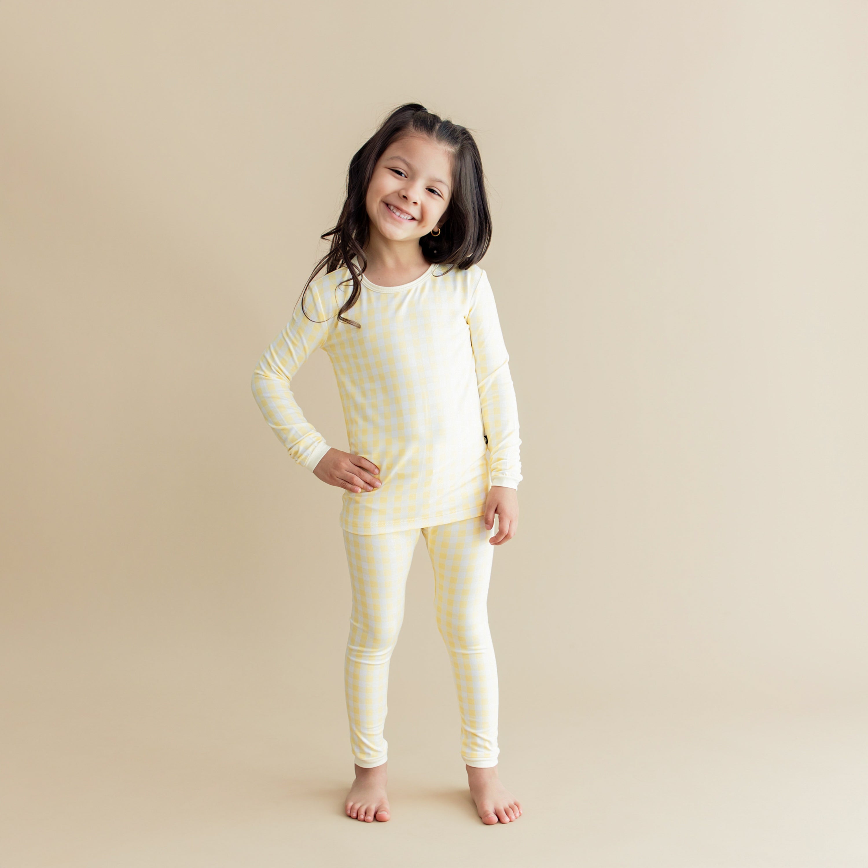 Young girl posing wearing the Long Sleeve Pajamas in Gingham Chamomile