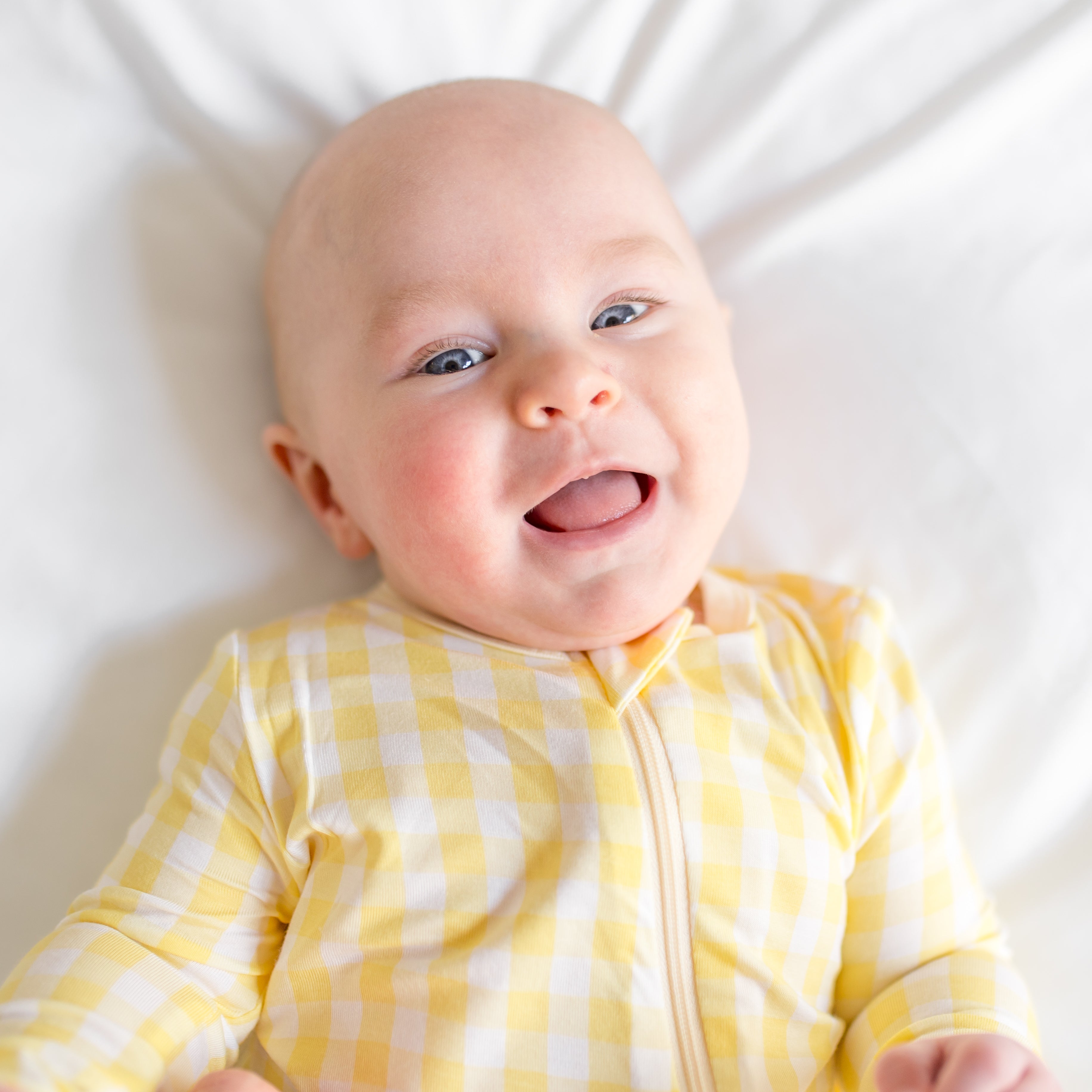 Close up of infant wearing the Zippered Romper in Gingham Chamomile