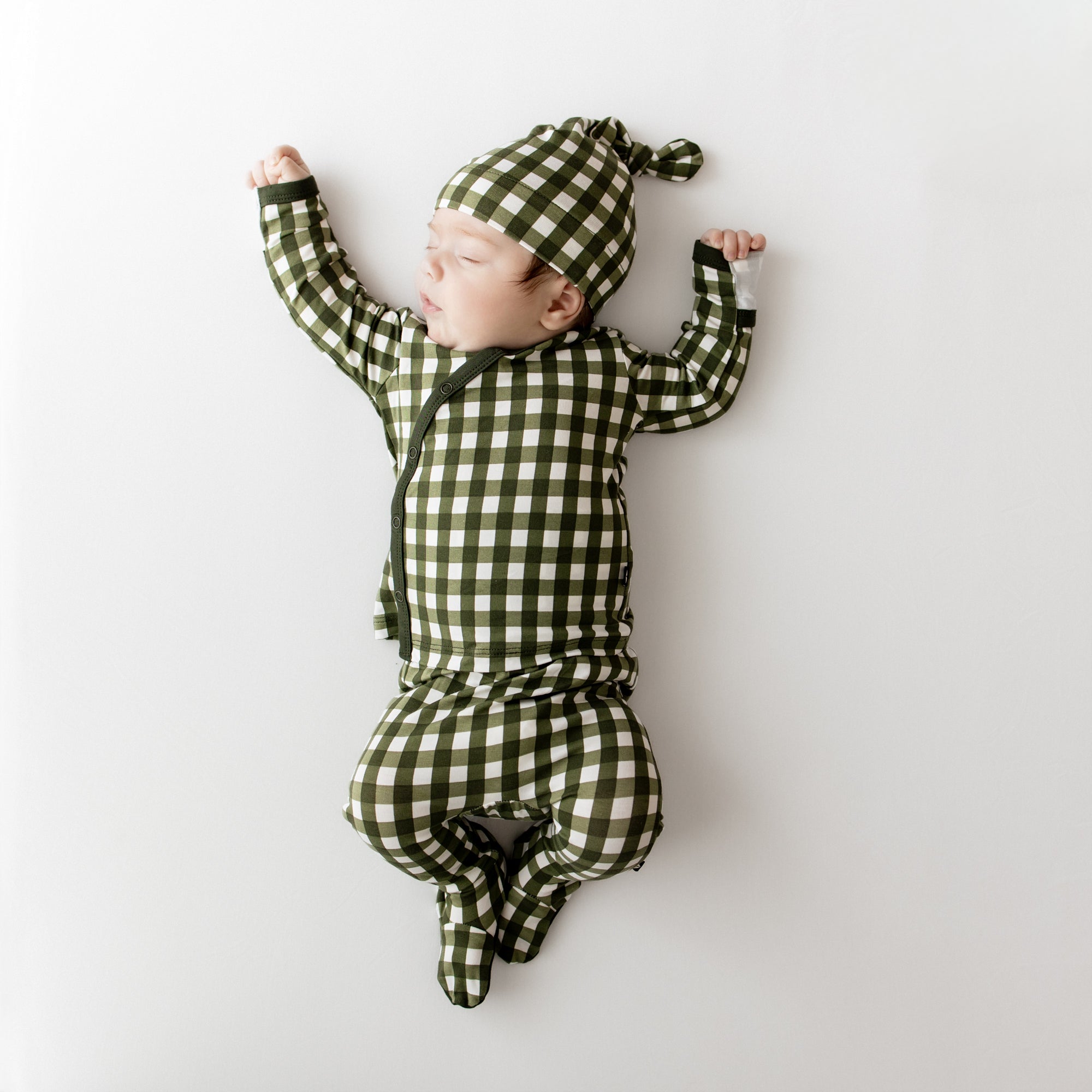 Sleeping infant wearing the Take Me Home Set with Cap in Gingham Fir