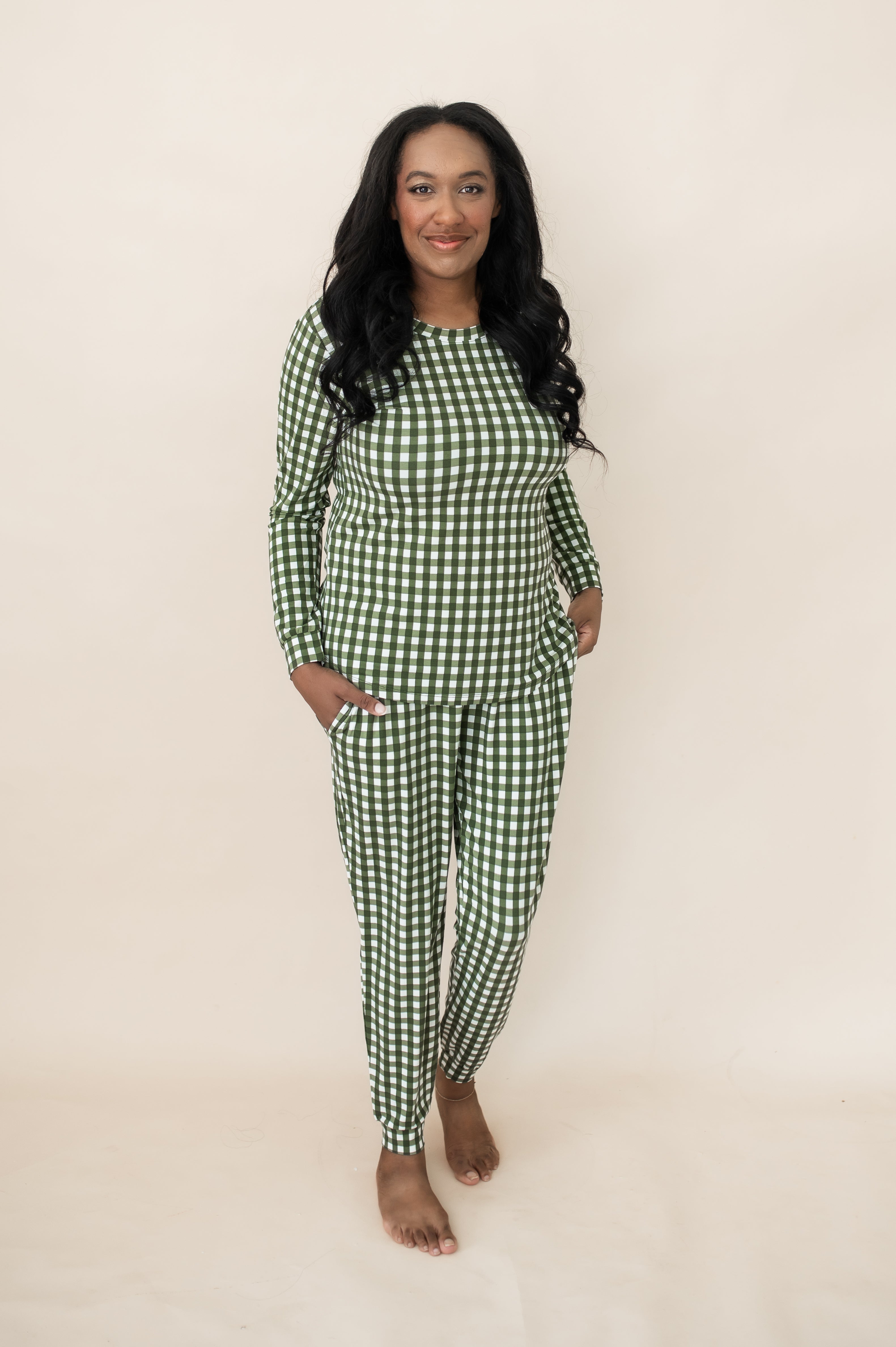 Female model wearing the Women's Jogger Pajama Set in Gingham Fir standing in front of a light neutral background