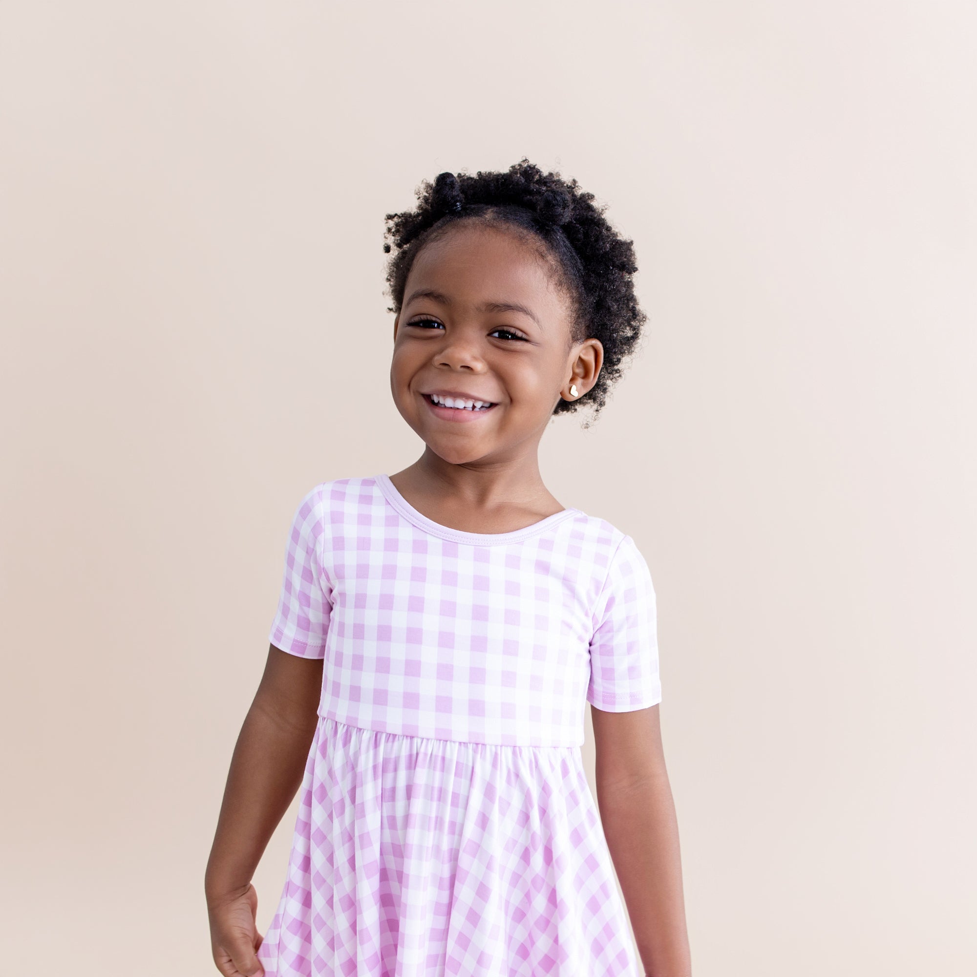 Close up of smiling girl wearing the Twirl Dress in Gingham Thistle