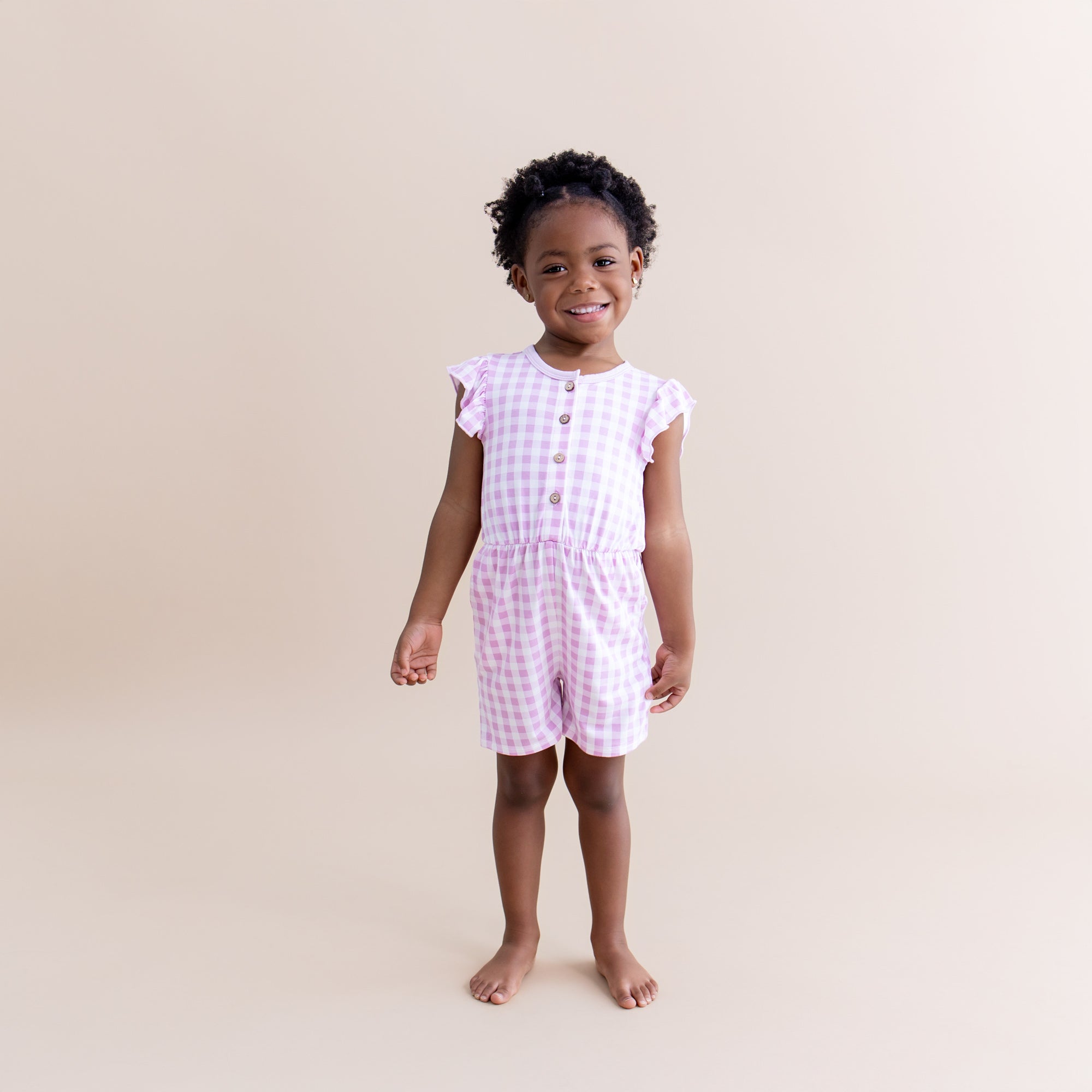 Young girl modeling the Flutter Sleeve Romper in Gingham Thistle