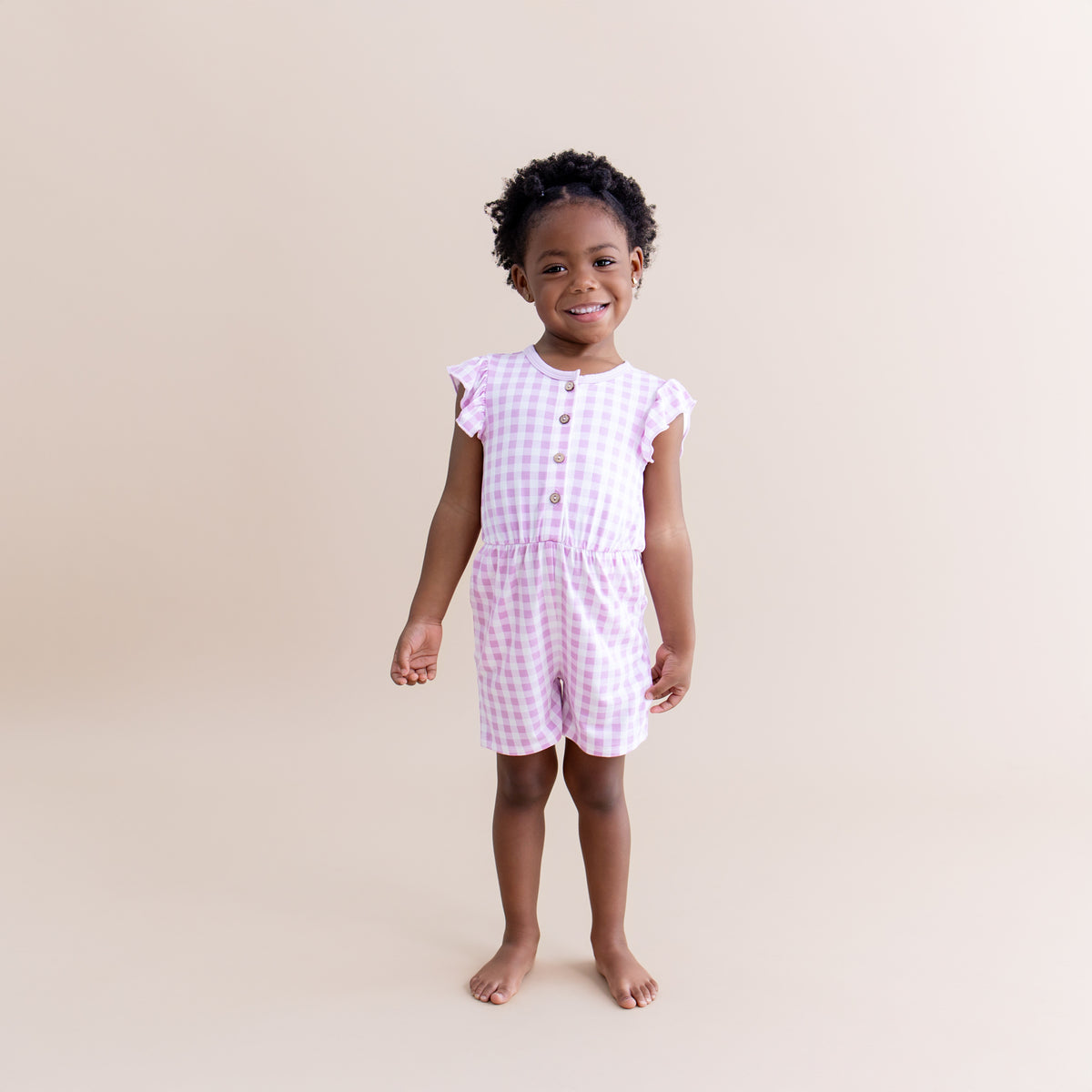 Young girl modeling the Flutter Sleeve Romper in Gingham Thistle