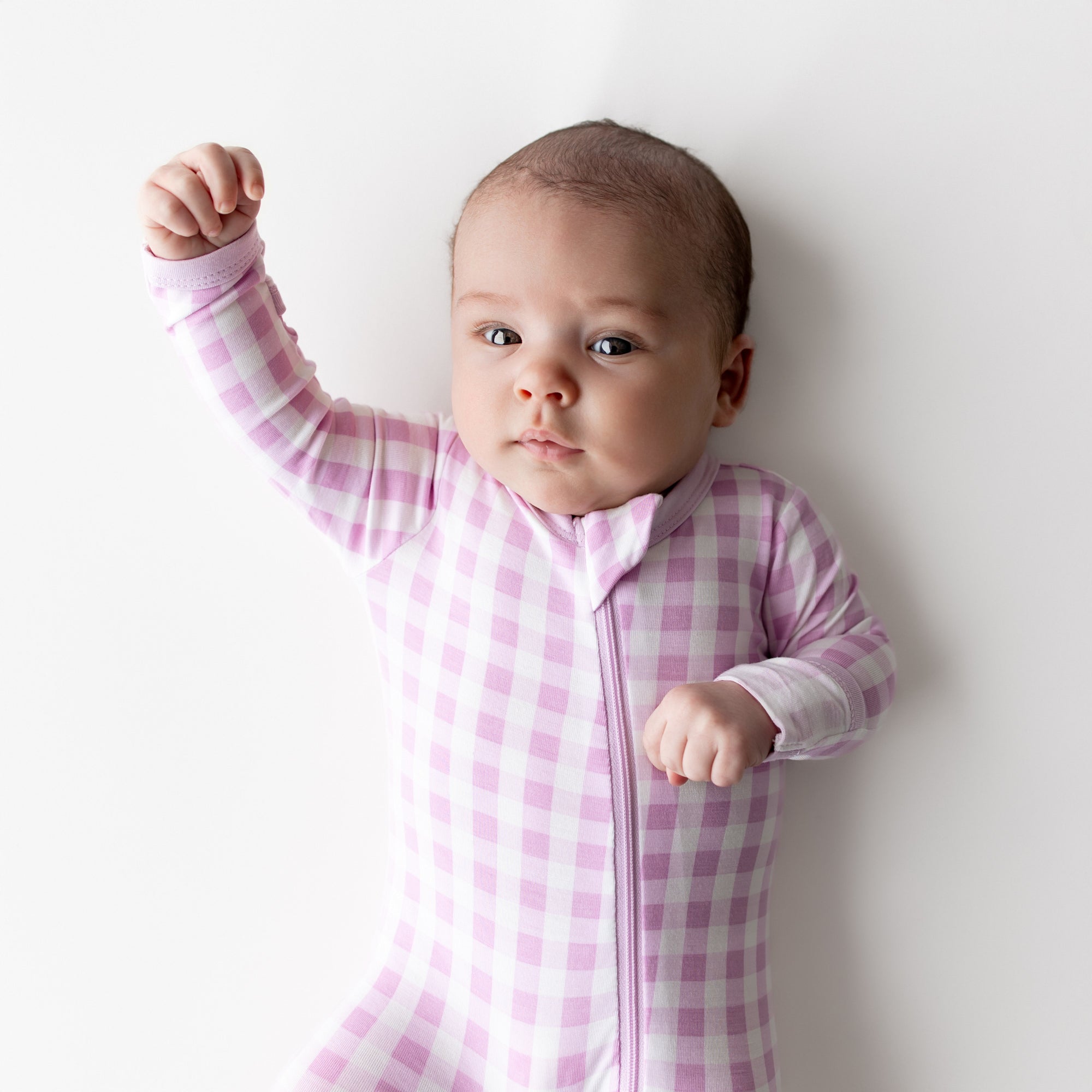 Close up of infant wearing the Zippered Footie in Gingham Thistle