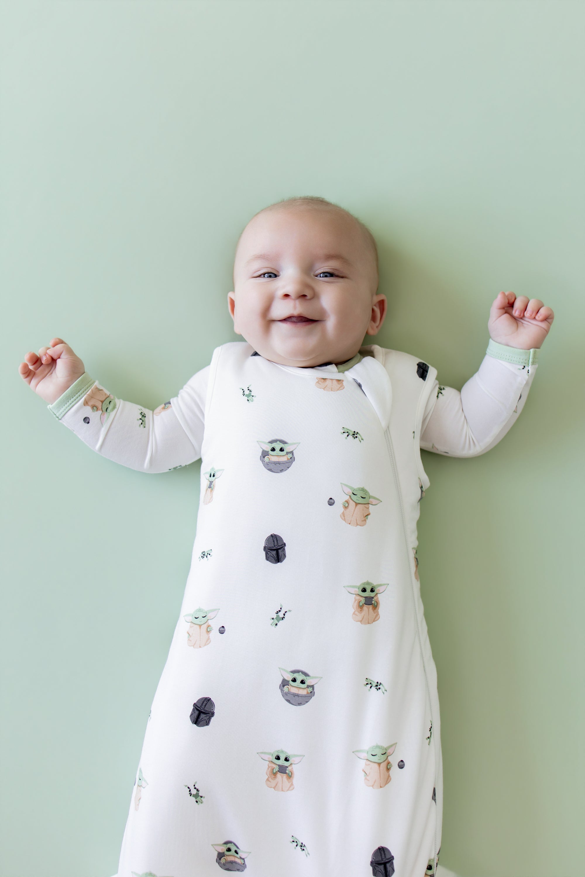 Close up of smiling infant wearing the Sleep Bag in Grogu™ 1.0 with matching romper on underneath