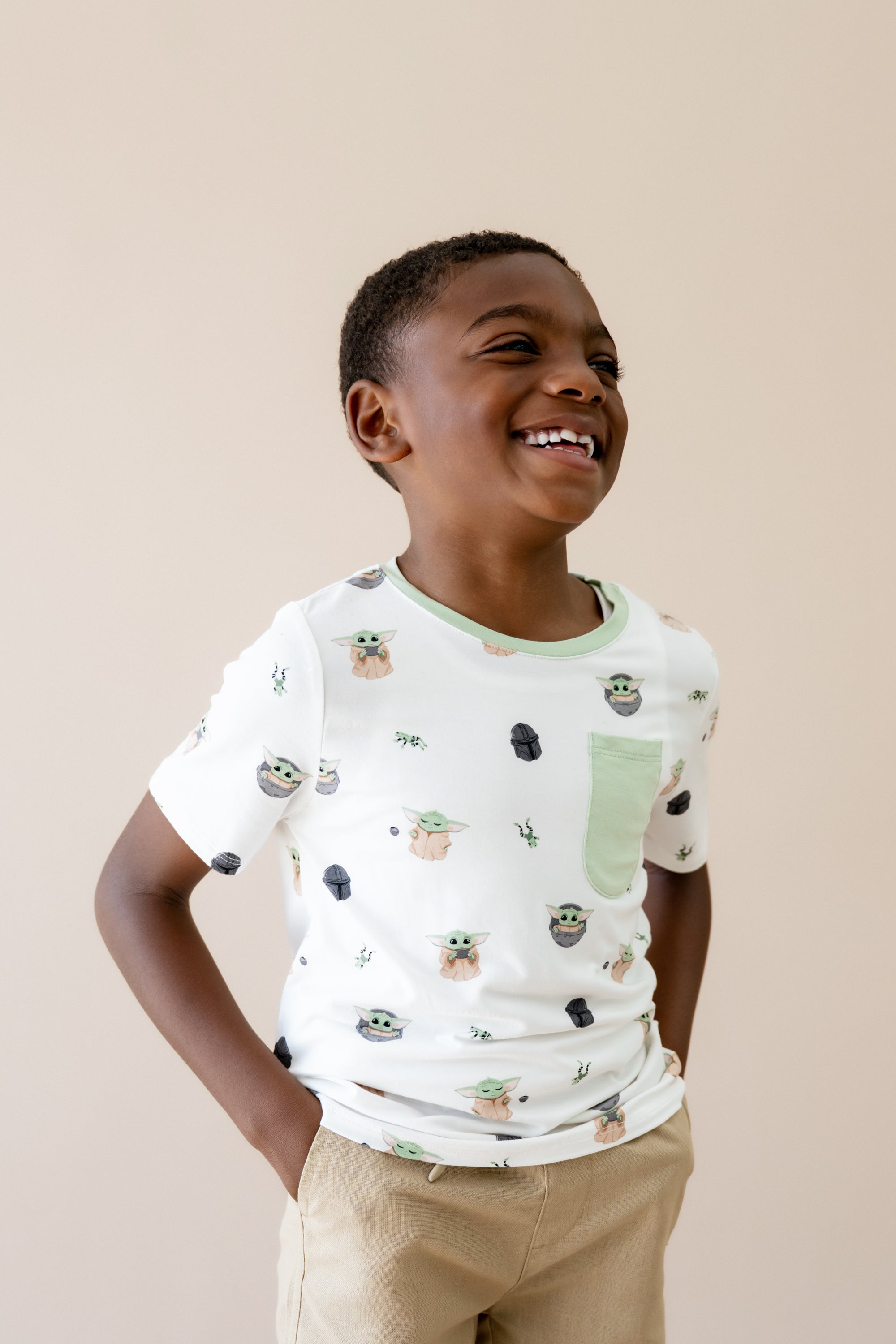 Smiling boy wearing the Toddler Crew Neck Tee in Grogu™