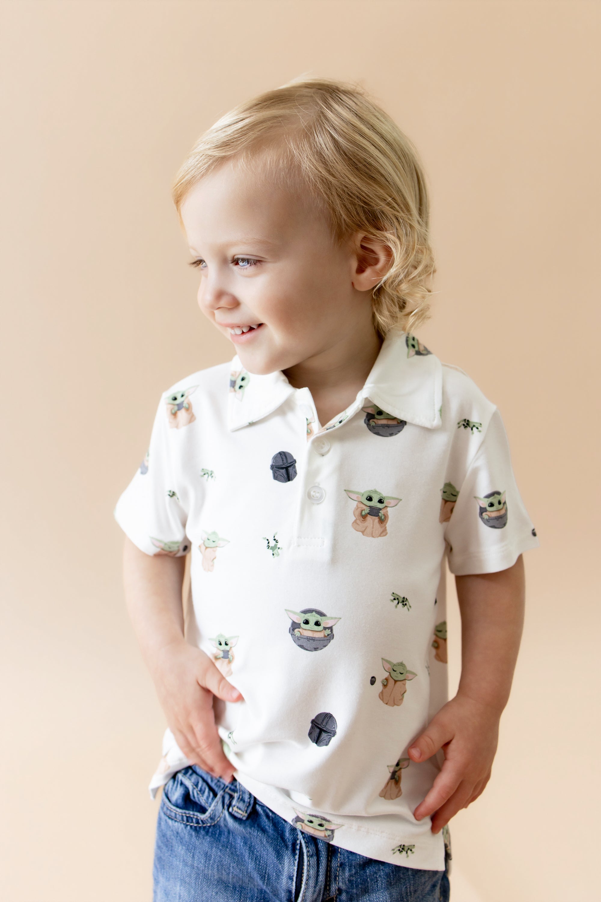 Smiling boy wearing the Toddler Short Sleeve Polo in Grogu™