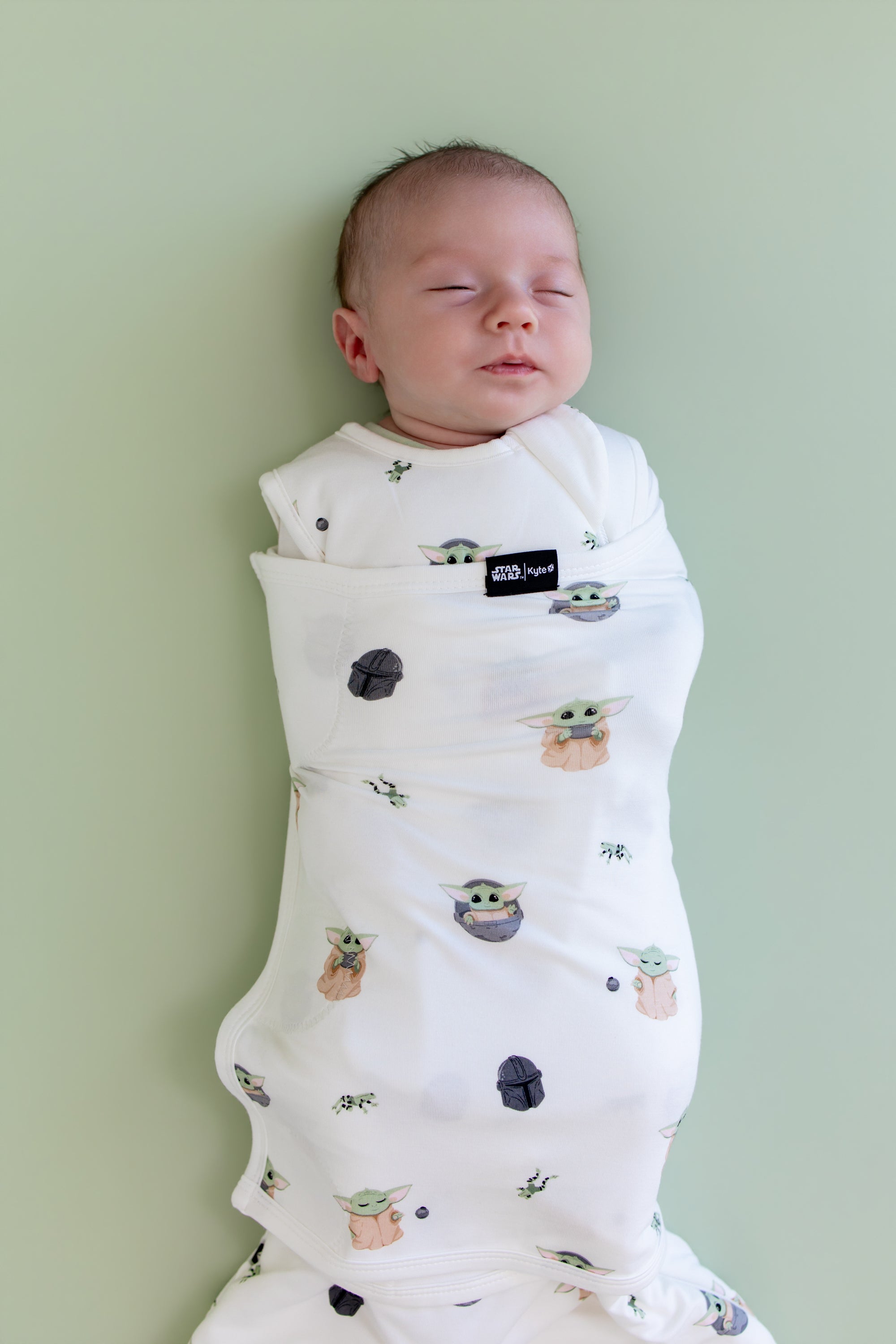 Close up of sleeping newborn swaddled in the Sleep Bag Swaddler in Grogu™ 1.0