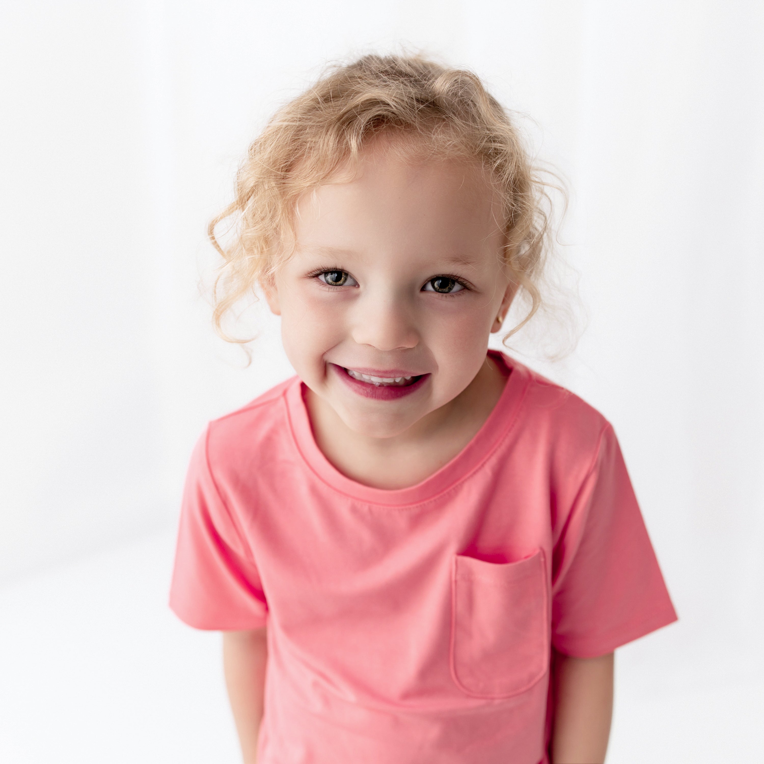 Girl wearing Toddler Pocket Crew Neck Tee in Guava
