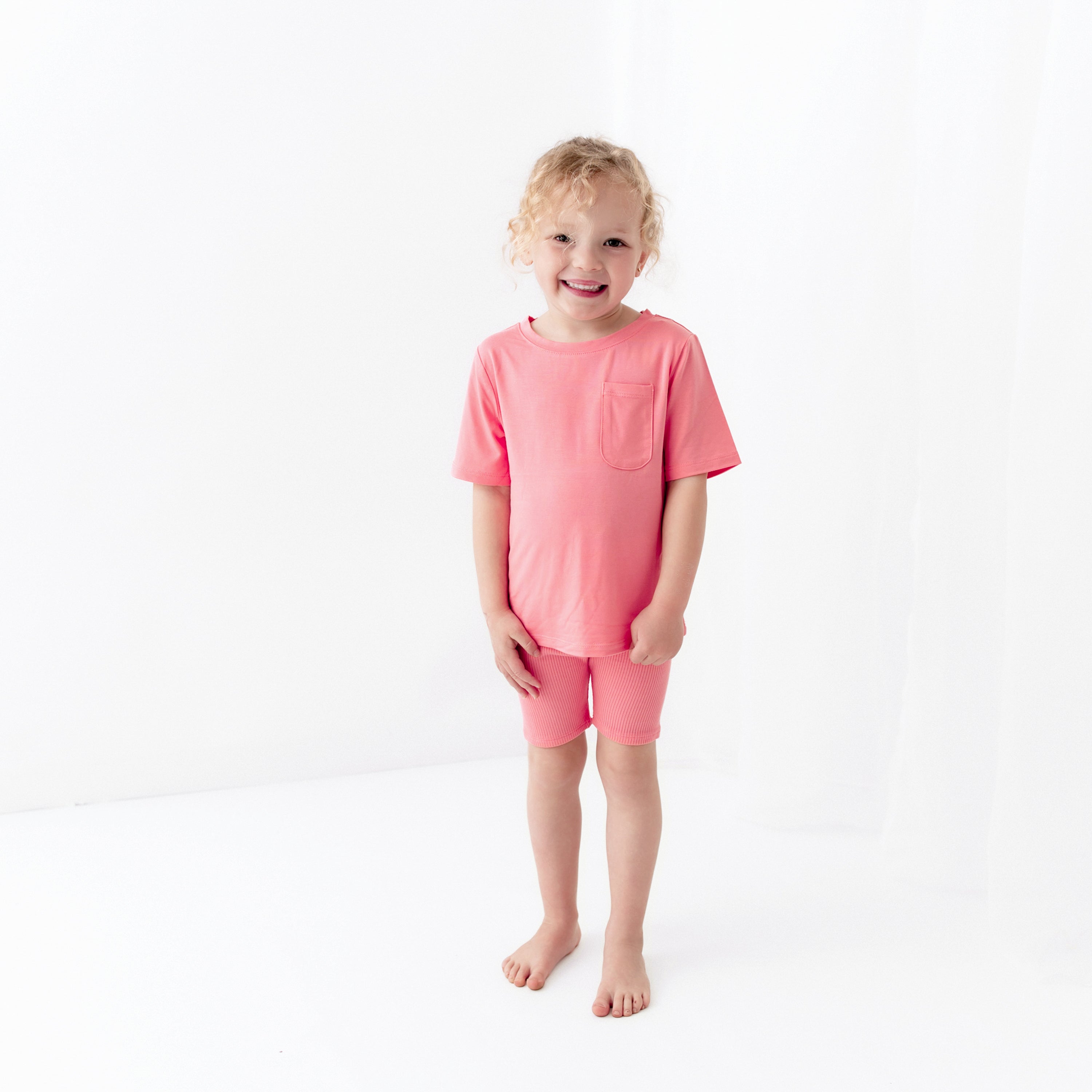 Girl wearing Toddler Crew Neck Tee in Guava Pink with matching ribbed shorts