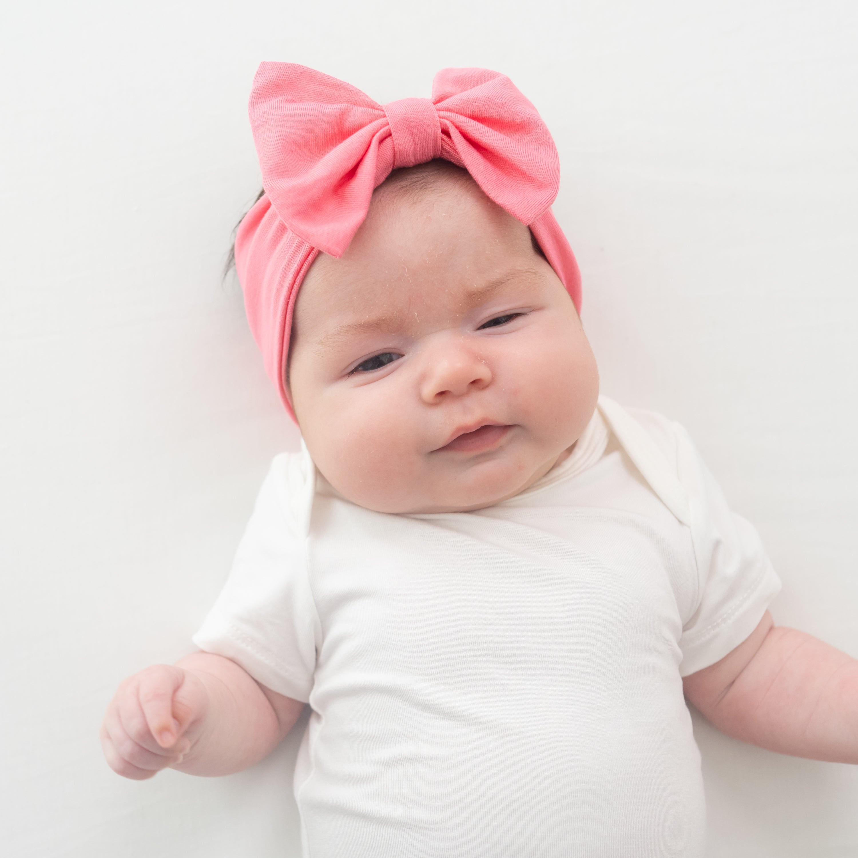 Baby wearing Bow Headband in Guava and cloud bodysuit