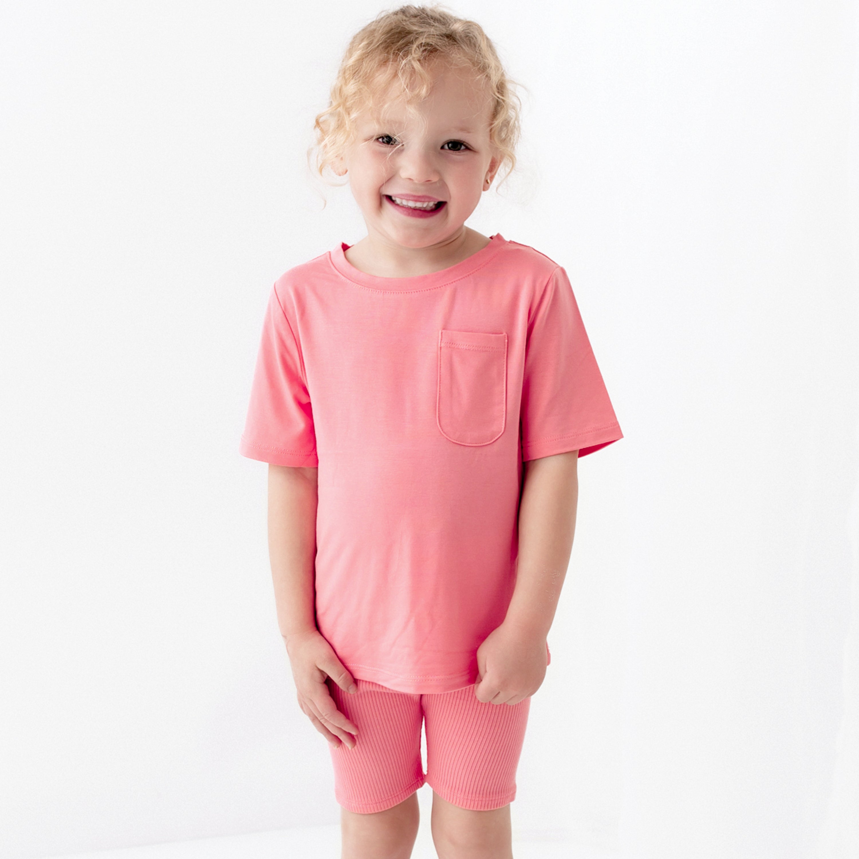 Child wearing Ribbed Toddler Biker Shorts in Guava with matching top