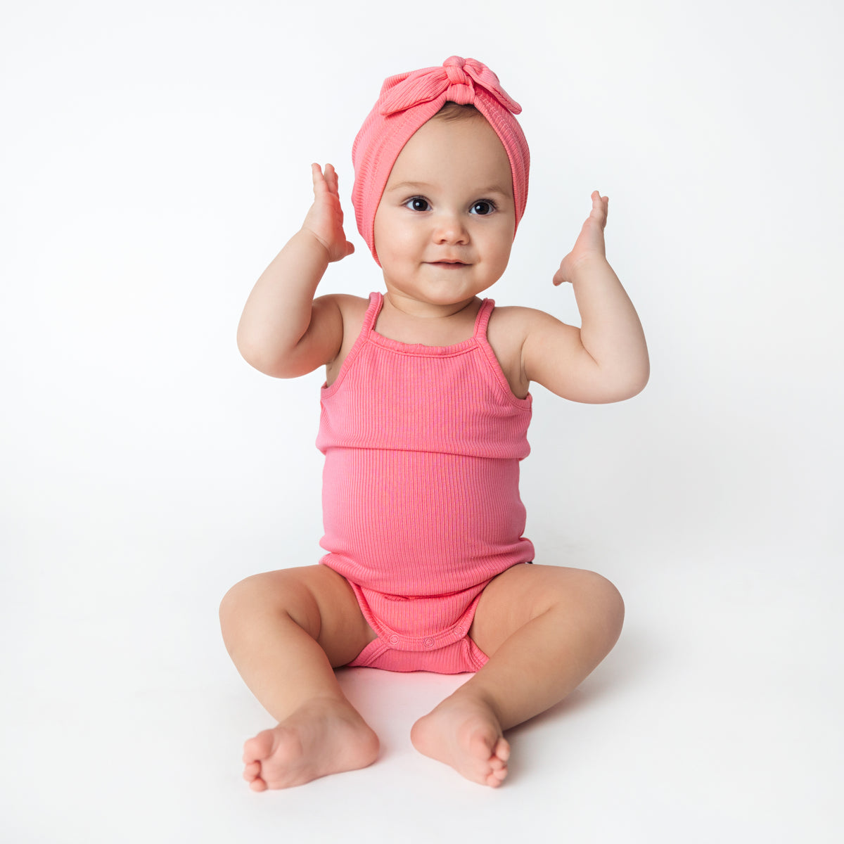 Baby wearing Ribbed Spaghetti Strap Bodysuit in Guava with Matching Headwrap