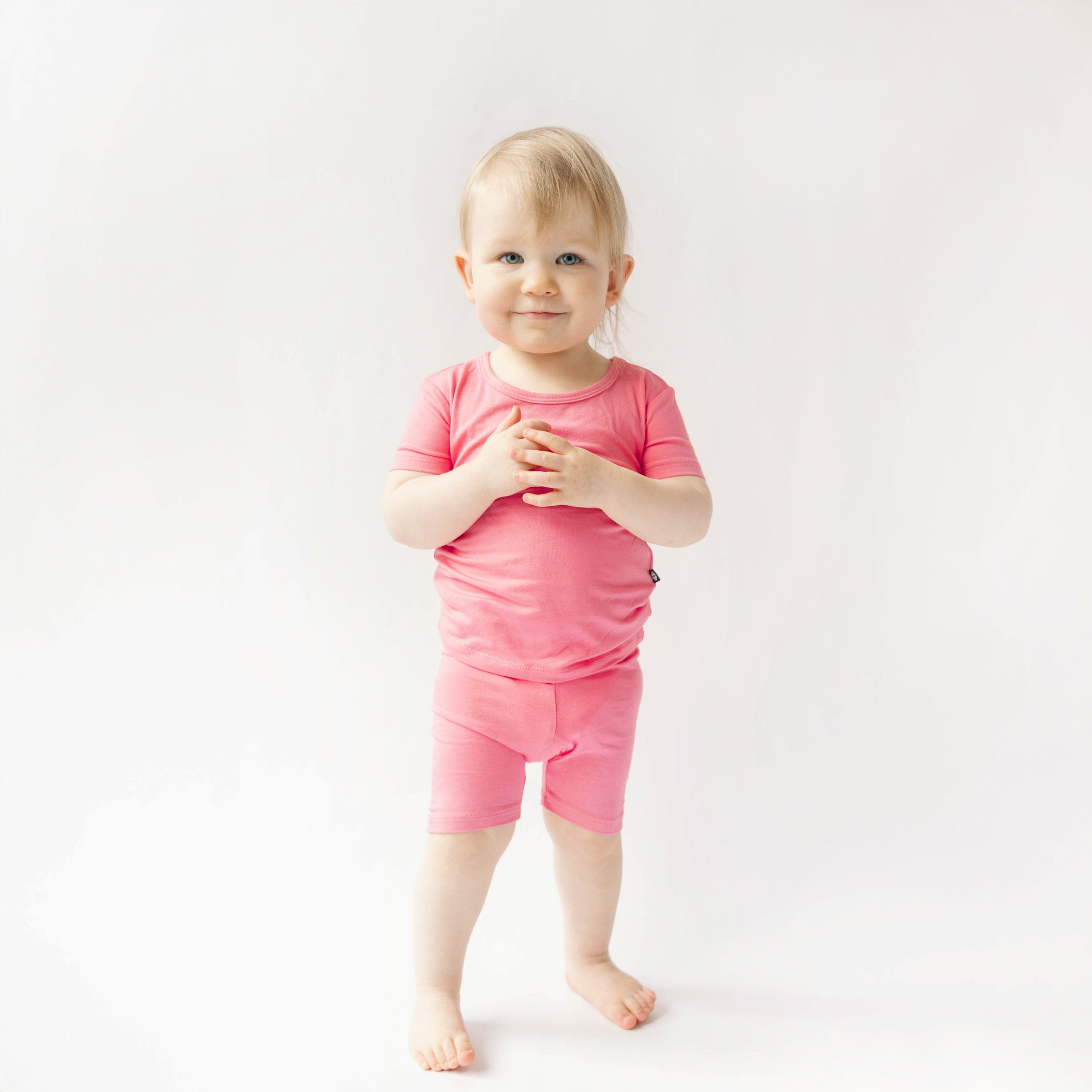 Toddler wearing short sleeve kids pajamas in guava