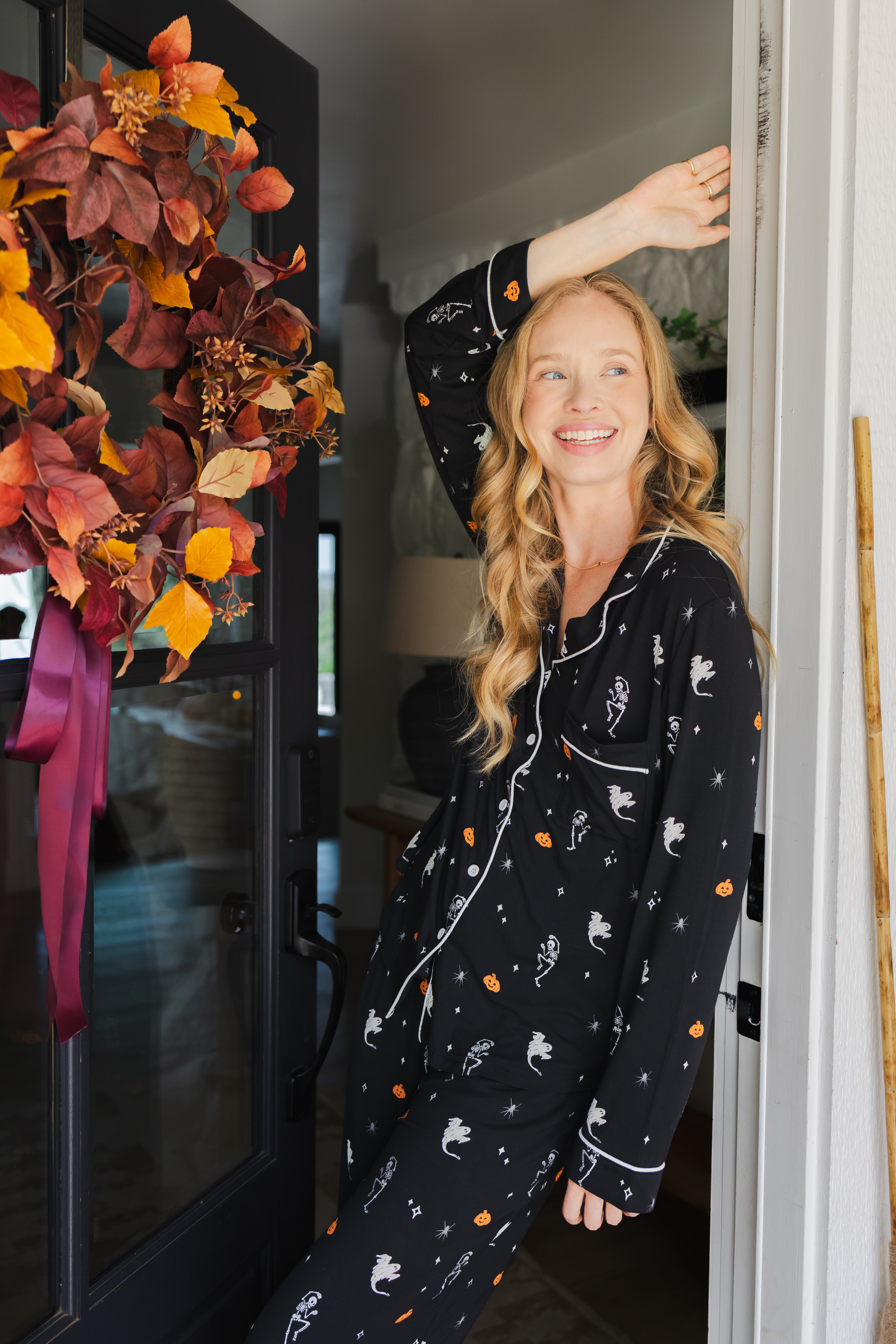 Modal smiling in door way wearing Long-Sleeved Women's Pajama Set in Halloween Friends print