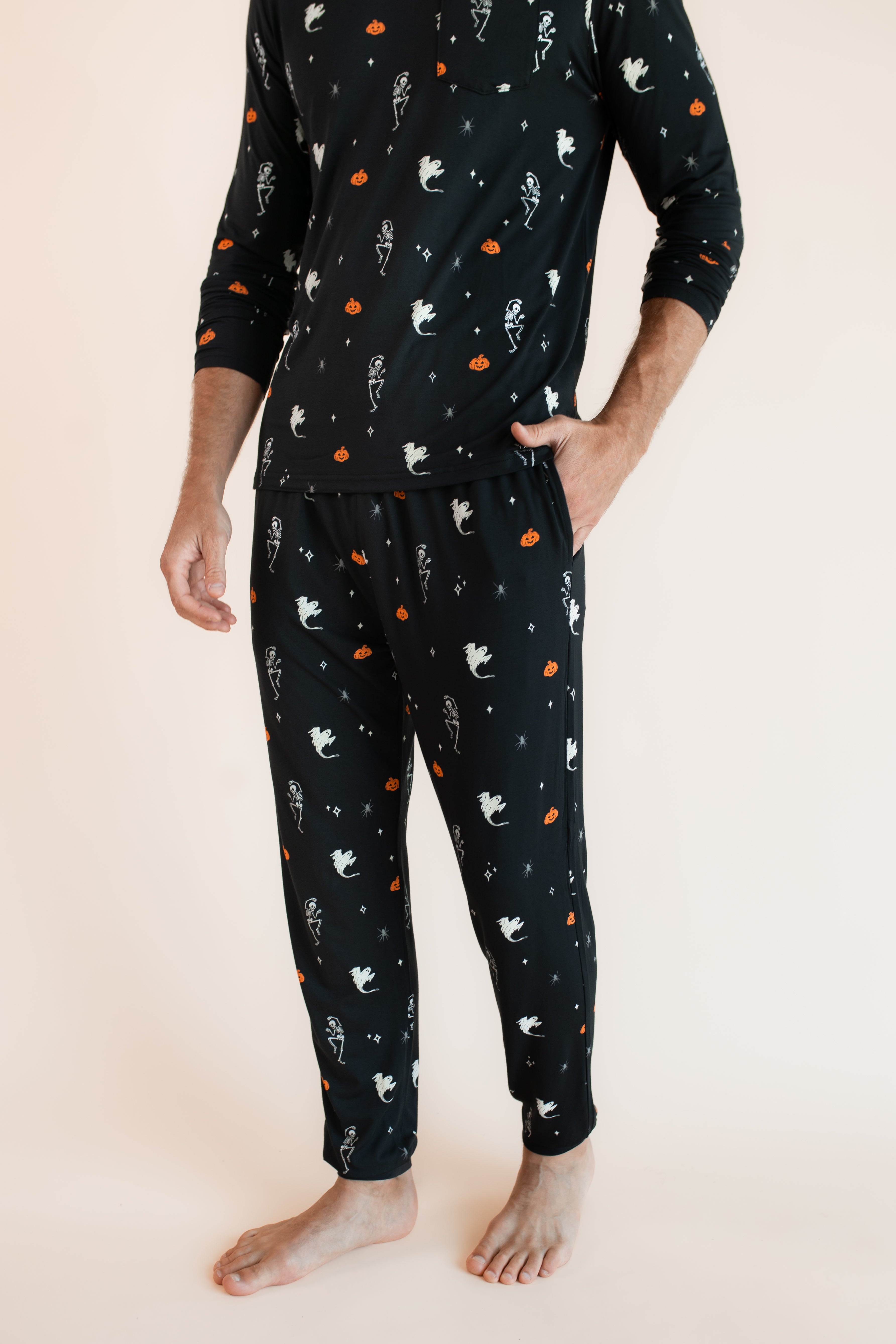 Modal wearing Men's Jogger Set in Halloween Friends print with hand in pocket on beige background