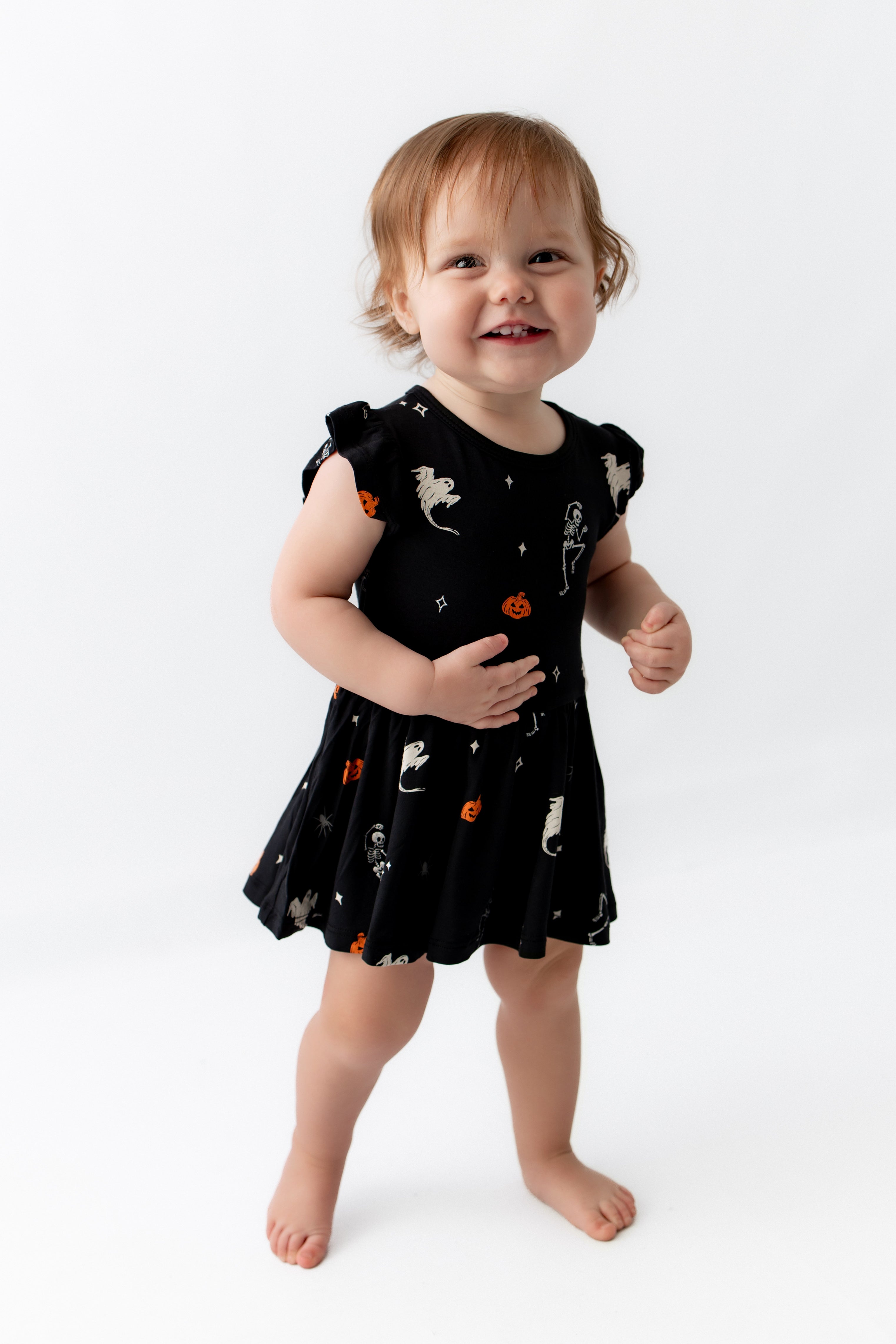 Girl wearing Twirl Bodysuit Dress in Halloween Friends print on a white background