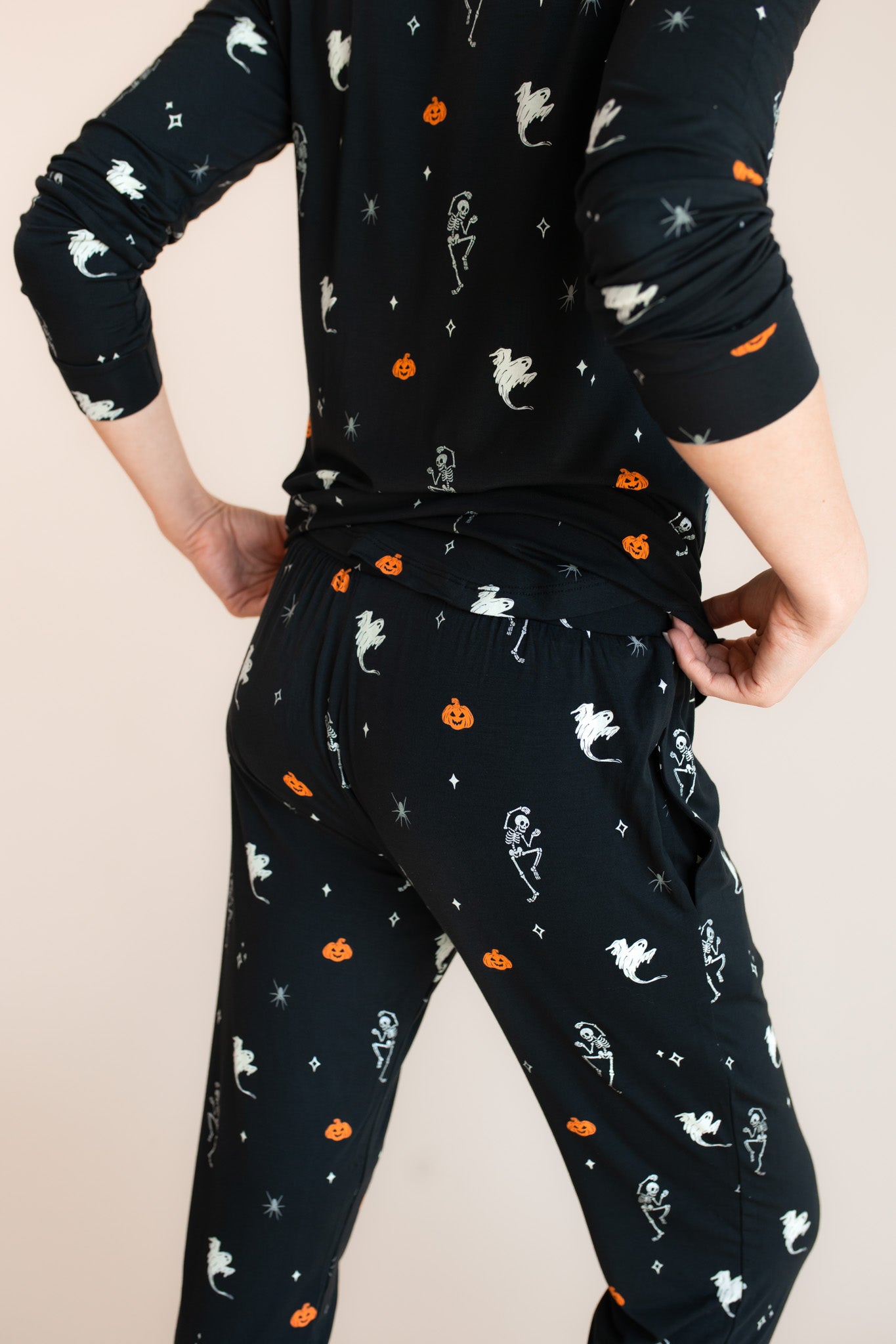 Back side of Modal wearing Women's Jogger Pajama Set in Halloween Friends print on a beige background