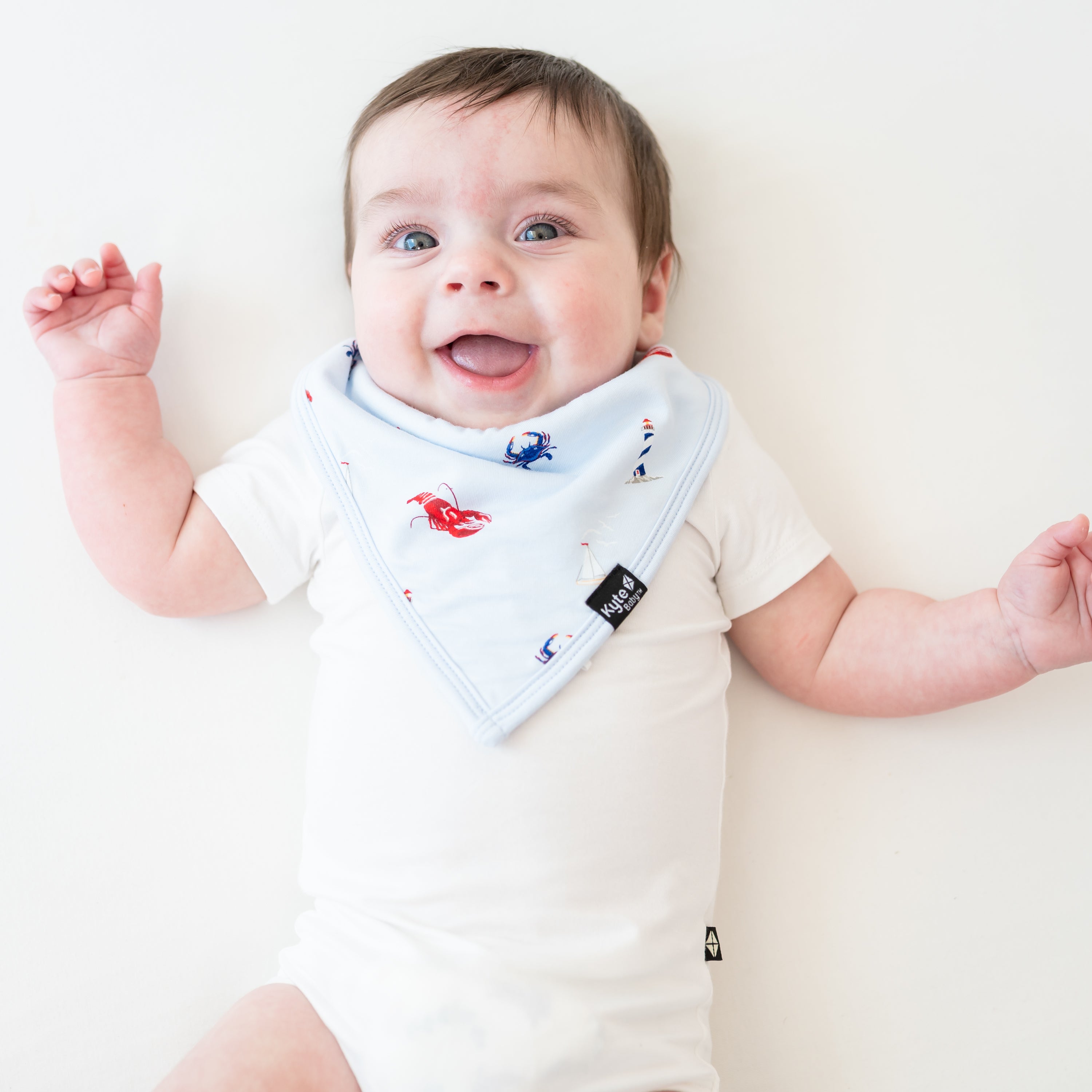 Infant wearing Bib in Harbor over white onesie