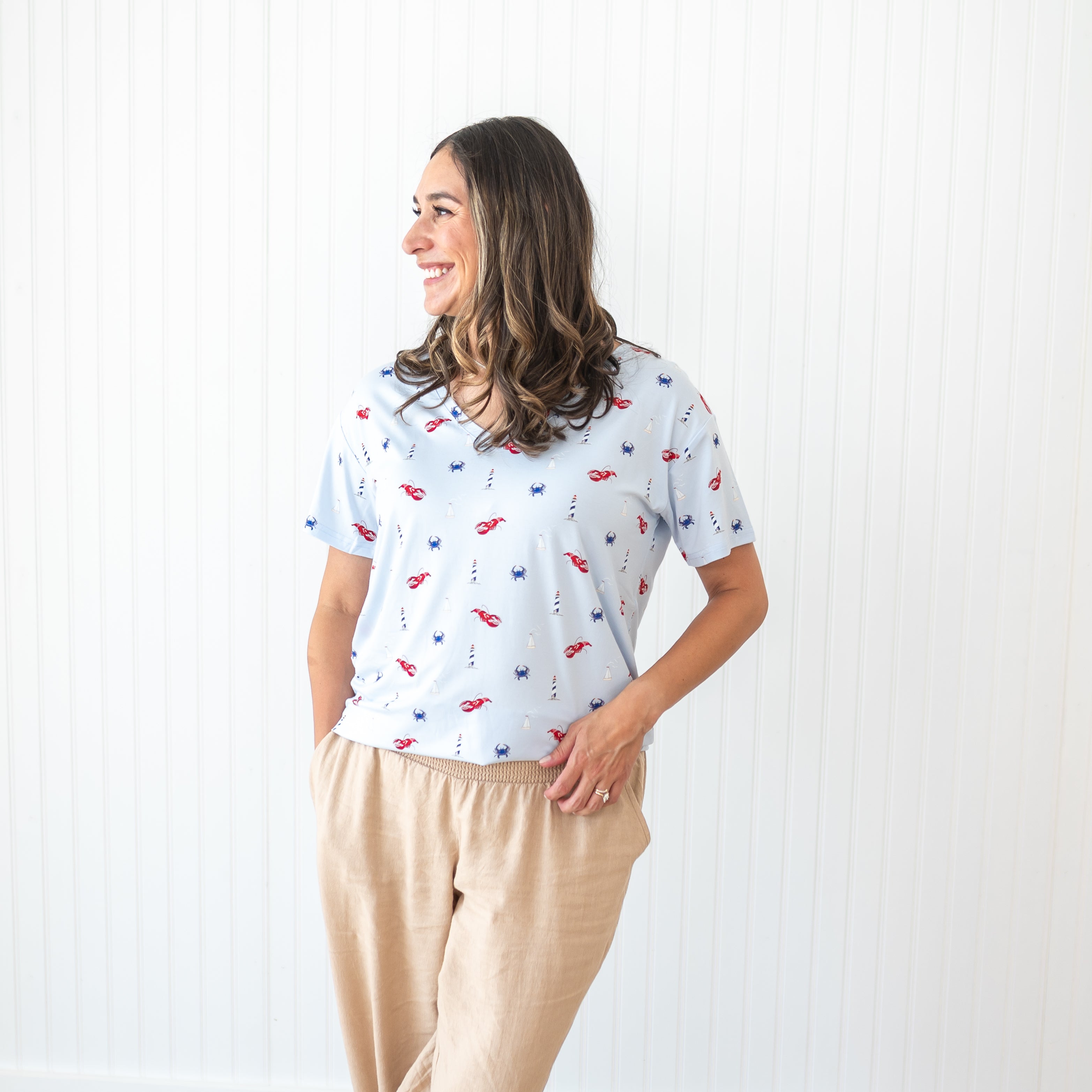 Smiling female model wearing the Women's Relaxed Fit V-Neck in Harbor paired with tan linen pants