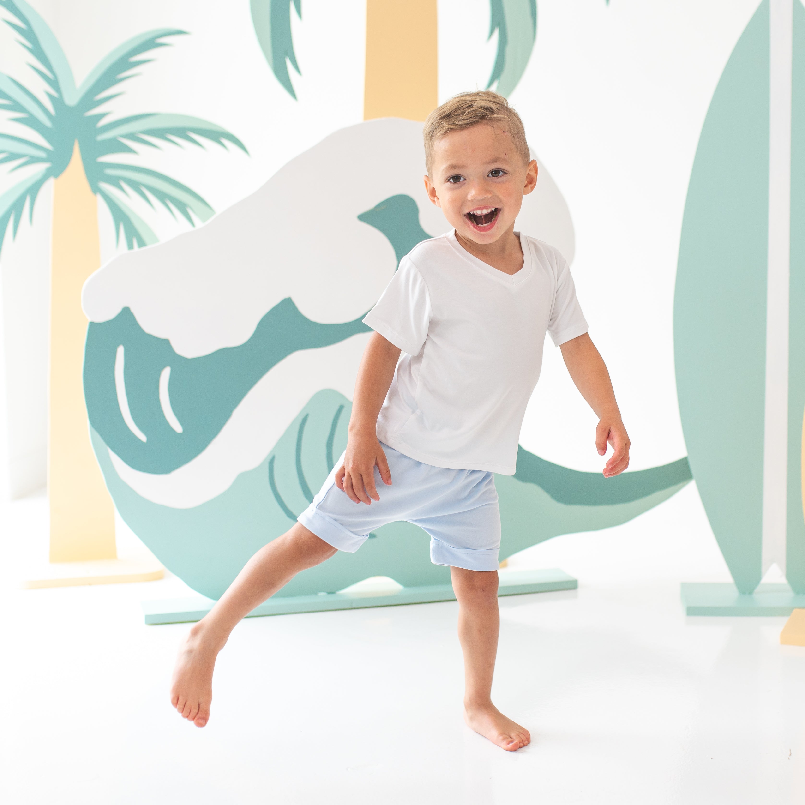 Smiling young boy wearing the Harem Shorts in Mist with a Toddler -Neck in Snow